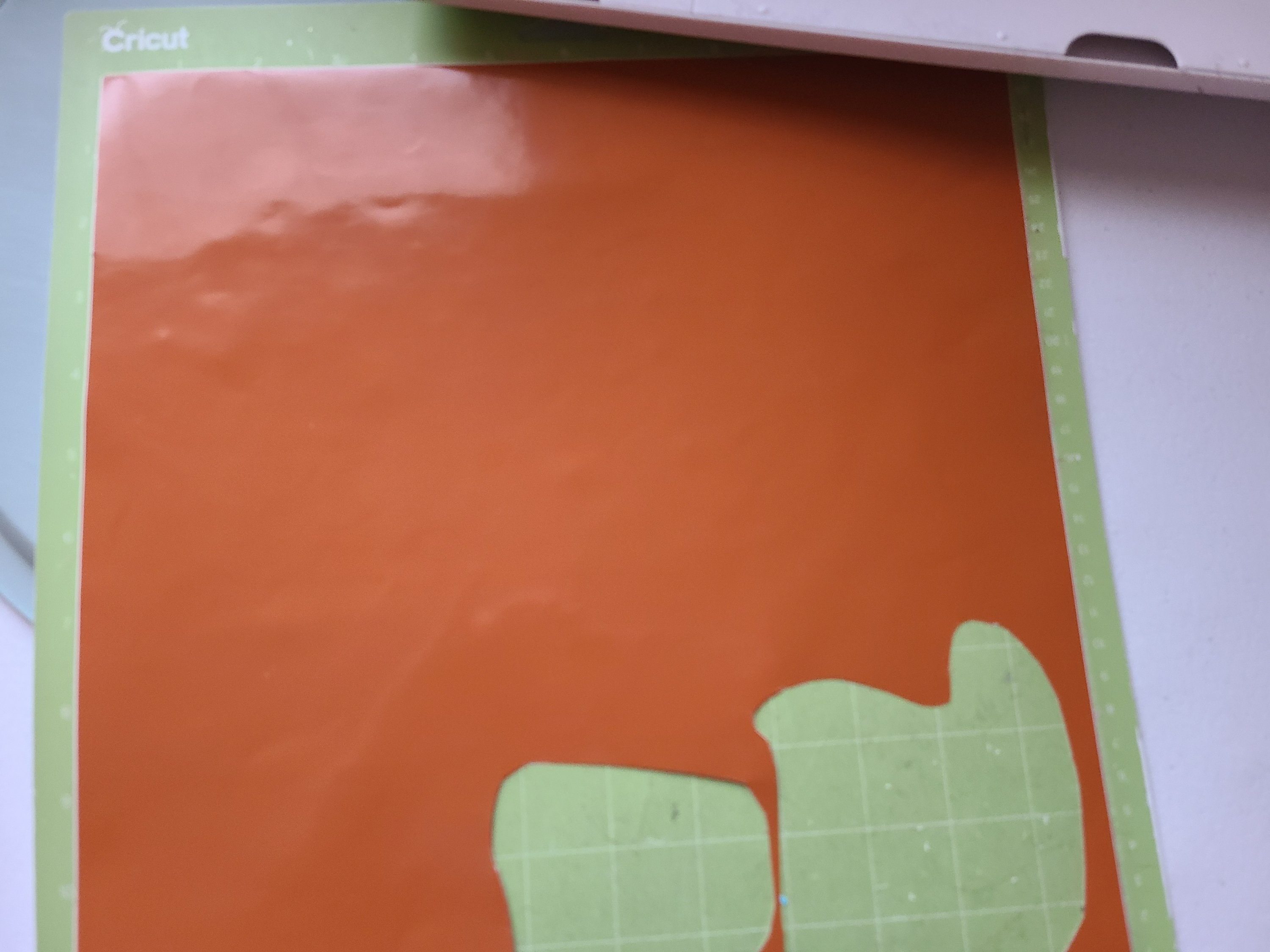 Orange vinyl placed on green standard grip Cricut cutting mat. This is the vinyl that will be used on the fall pizza pan wreath and the fall sign.
