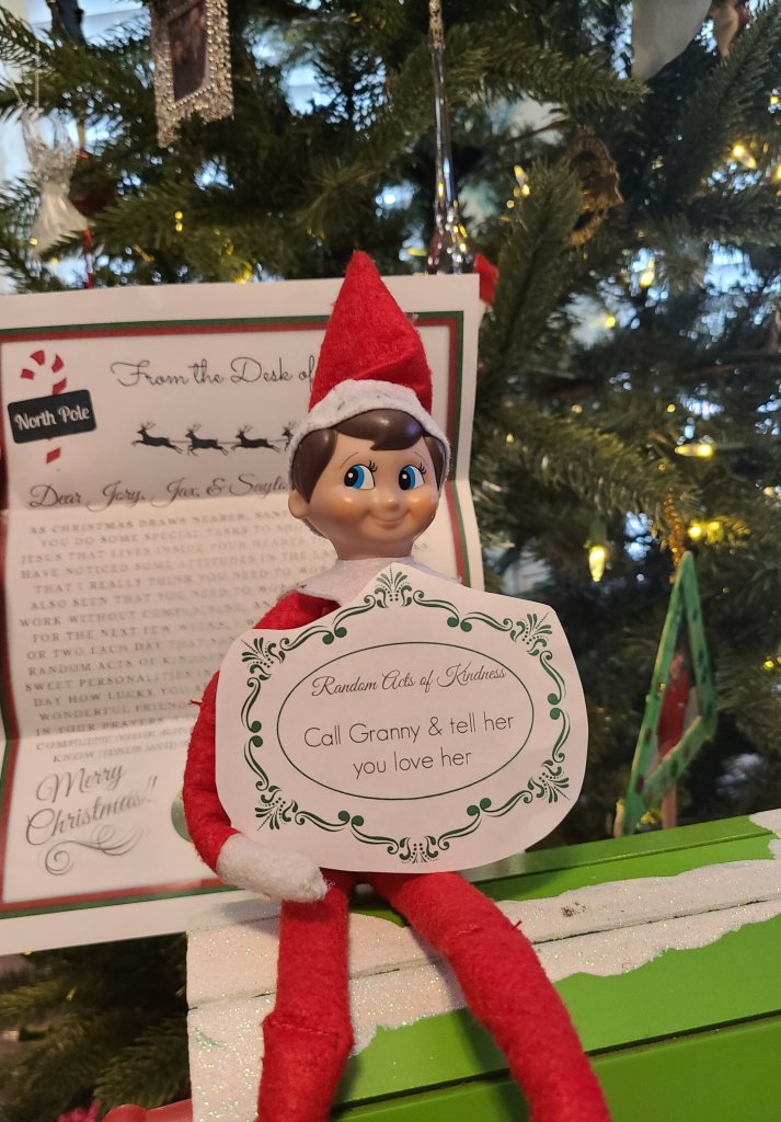 Elf holding RAOK and letter from Santa