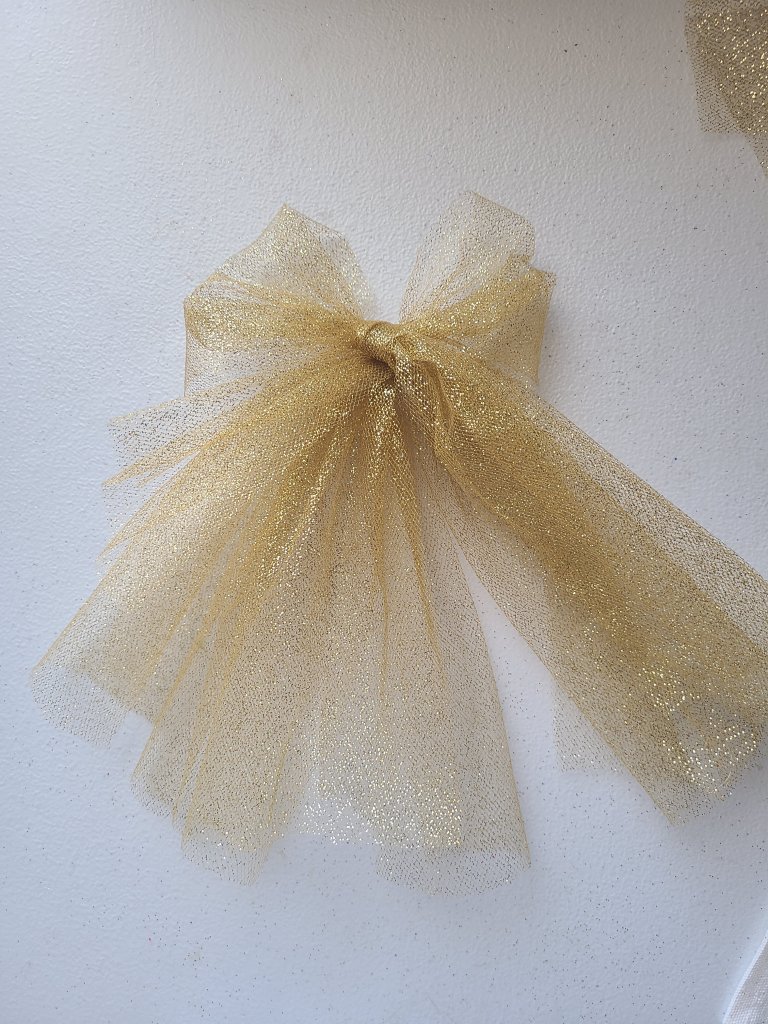gold tulle bow to glue to the top of the Valentine's wall hanging.