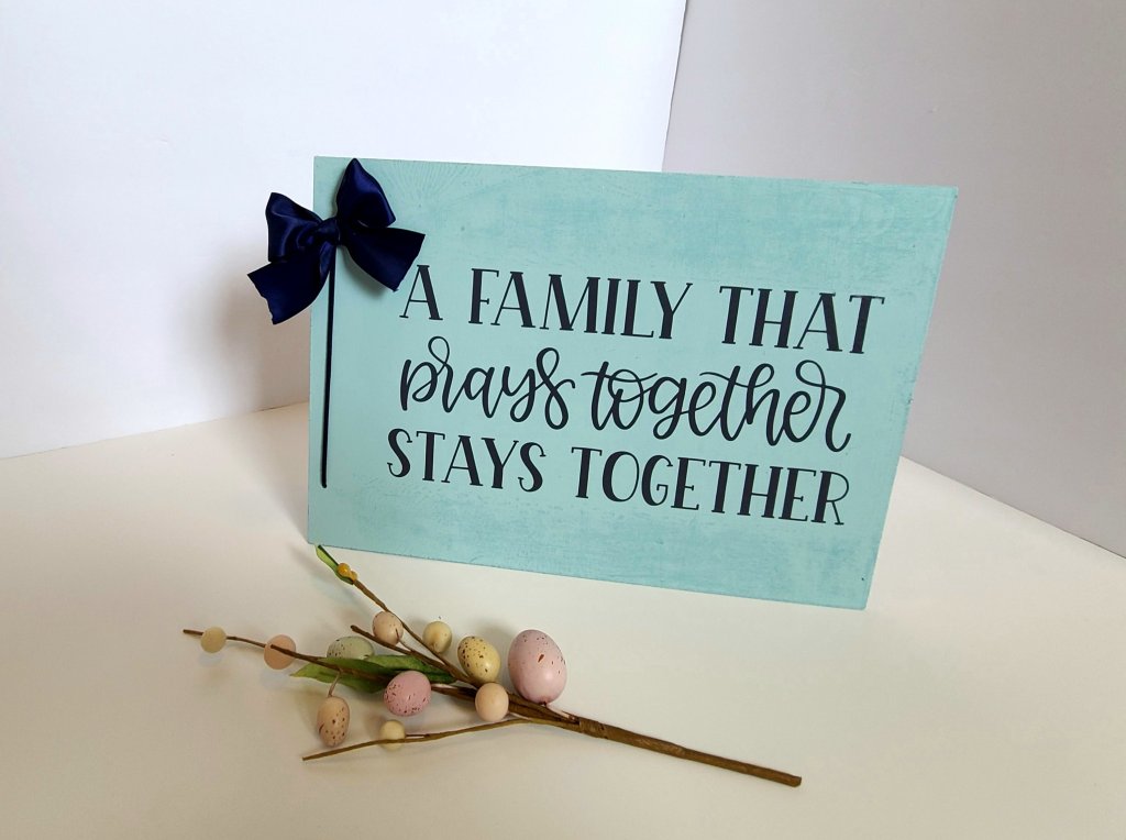 Robin's egg blue sign with gray vinyl quote. Navy blue leather cord along the side with a navy bow.