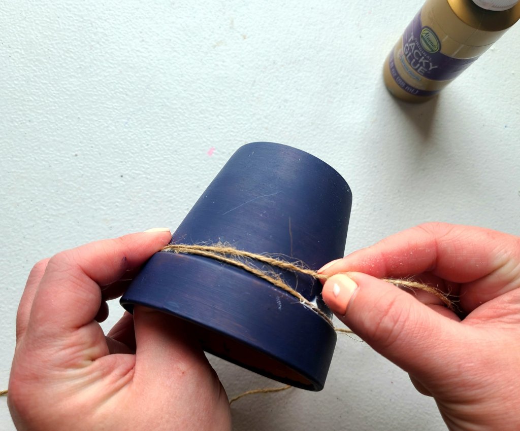 Starting a second line of twine around the flower pot that will be the nautical candleholder.