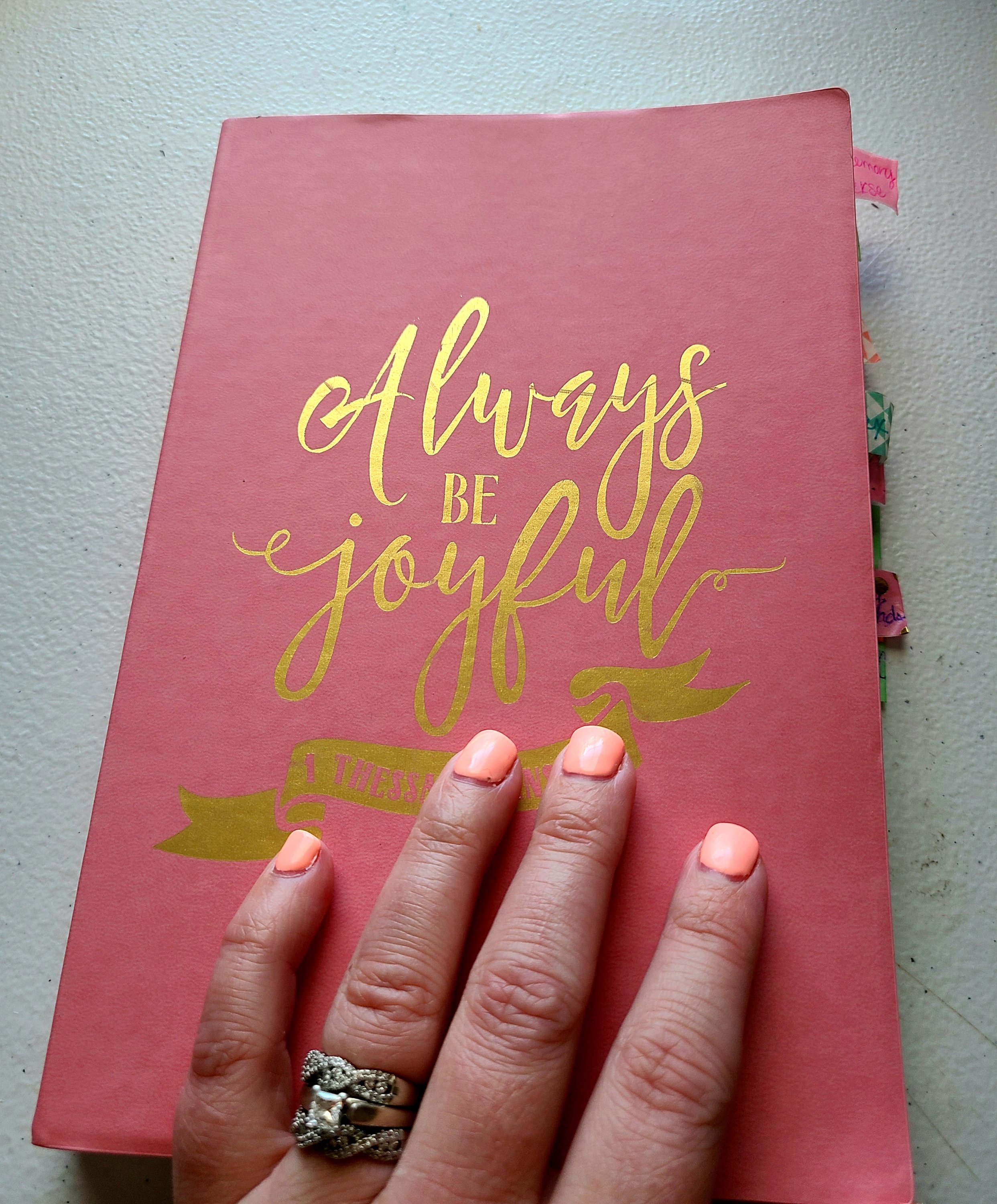 Cover of my prayer journal. A pink notebook with "Always be joyful" written in gold.