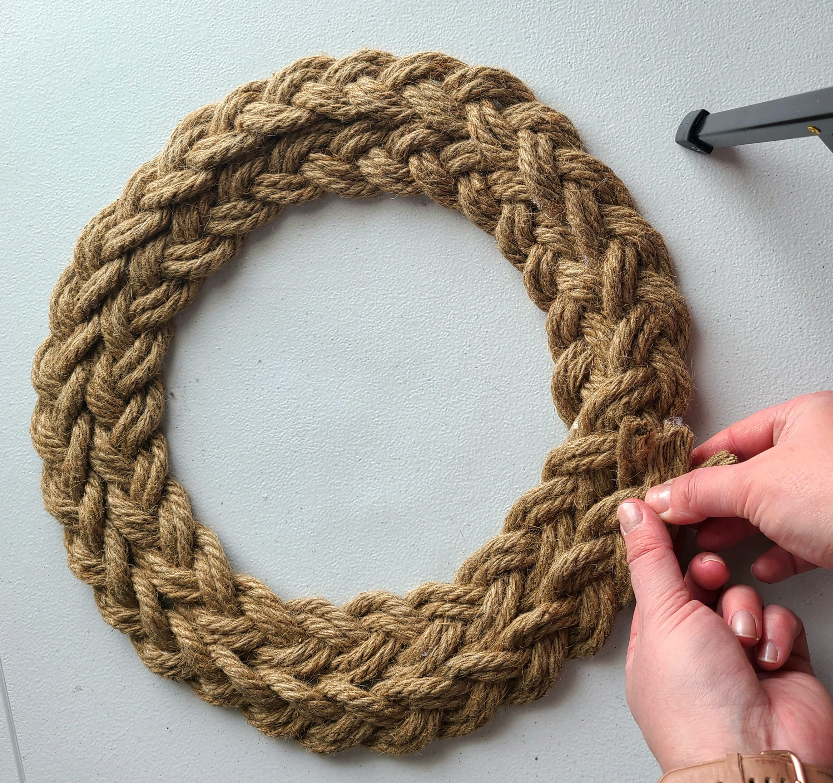 Gluing the end of the rope braid to the nautical wreath to finish it off.