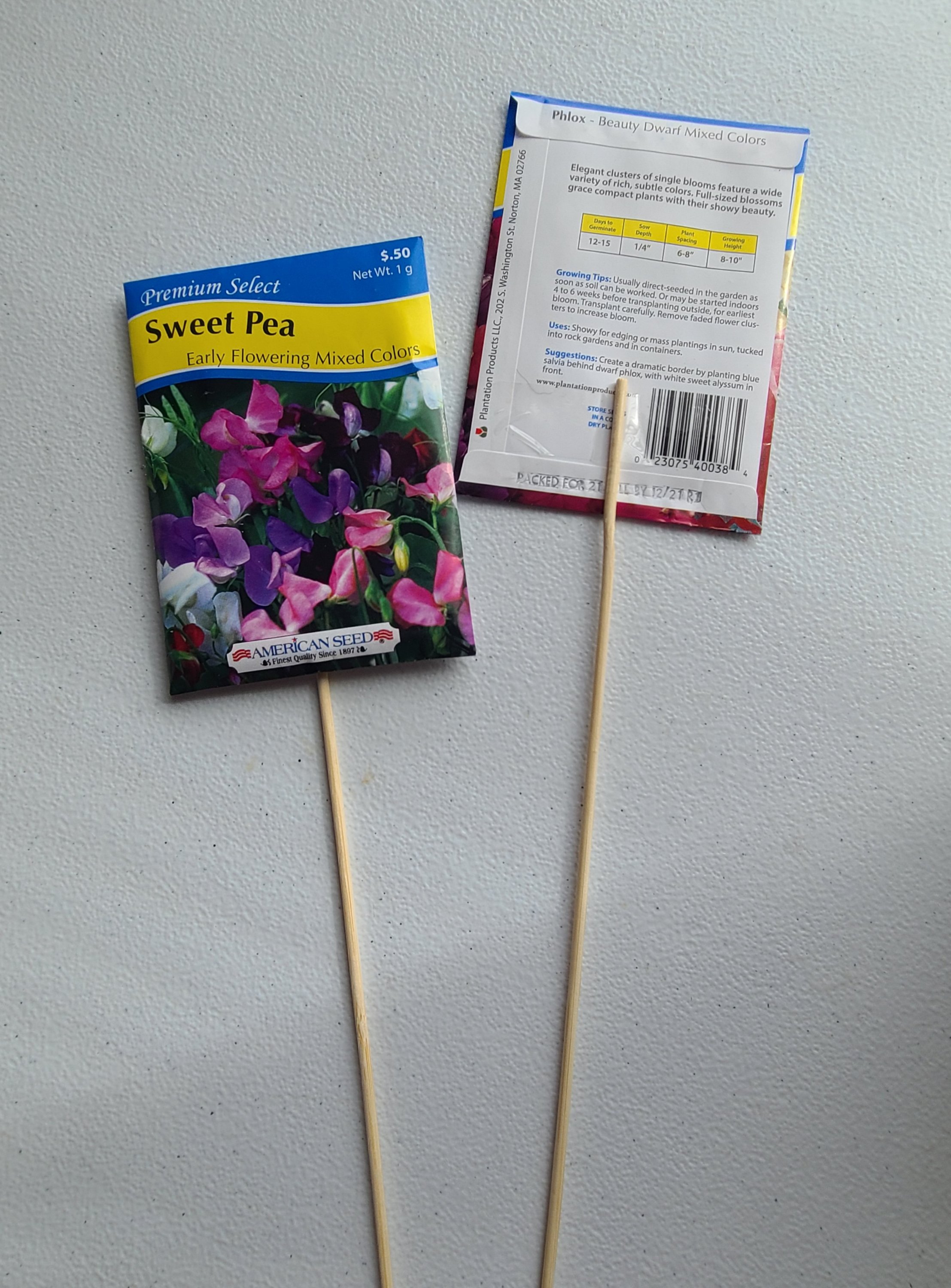 Flower seed packets taped to wood skewers so they can be stuck into the end of the school year teacher gift with the free printable gift tag.