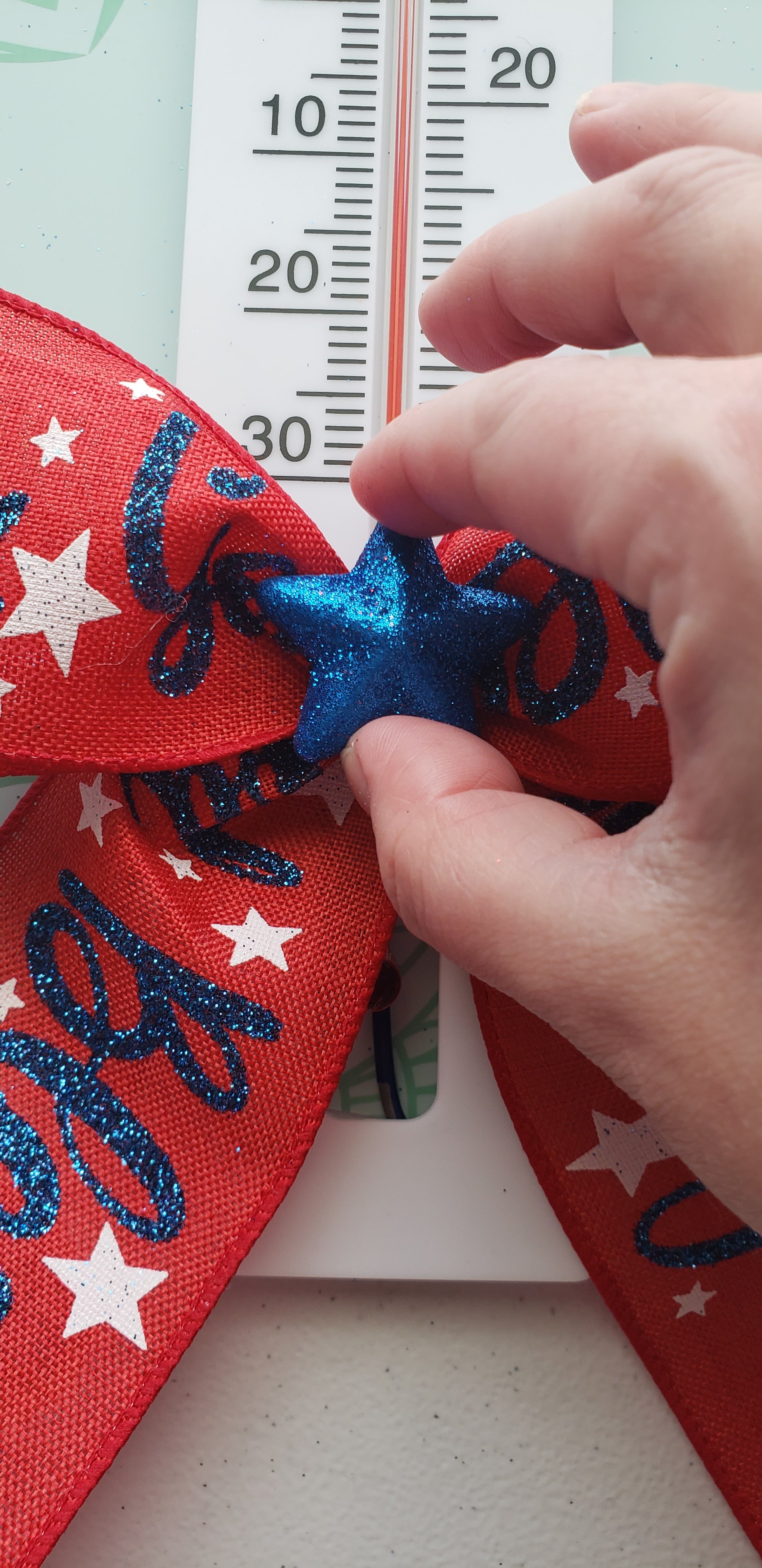 Gluing a blue scatter star to the center of the red, white, and blue bow.
