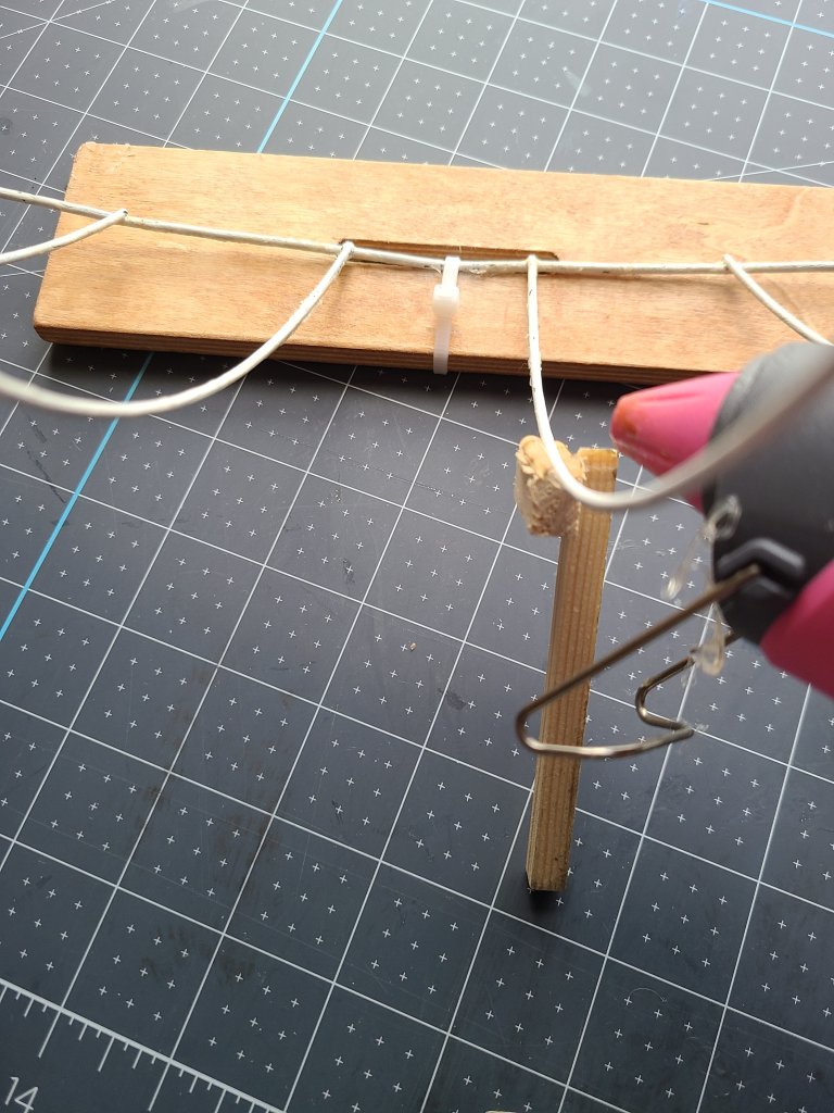 Place hot glue on the wood piece that will hold up the DIY fall centerpiece.