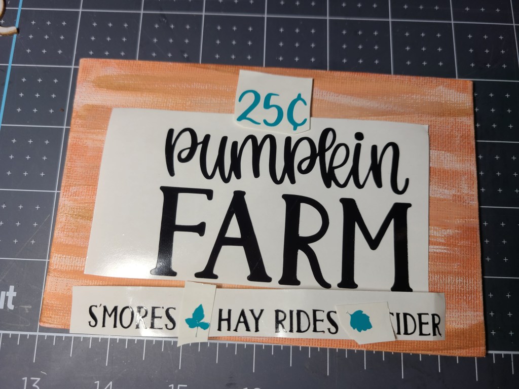 Vinyl lettering on the canvas that will be added to the top of the DIY fall centerpiece.