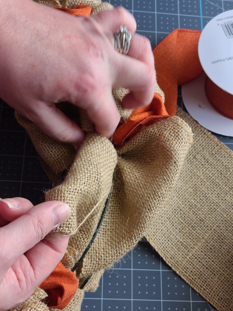 Pulling burlap through the middle ring of the burlap wreath form.