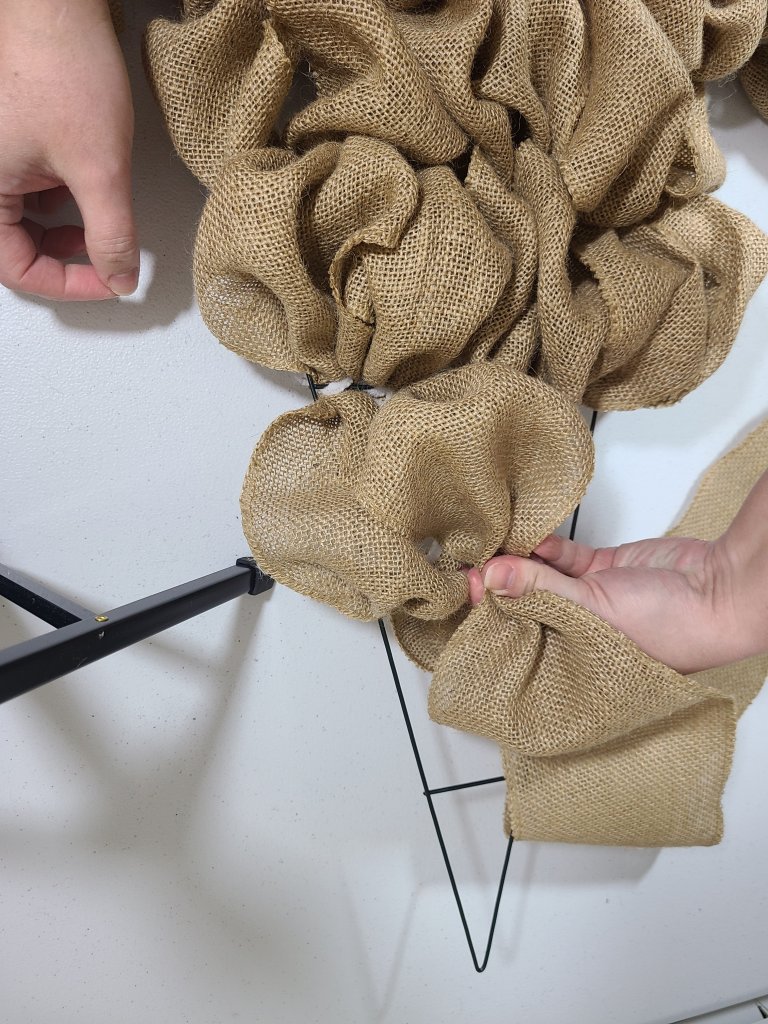Creating a burlap bubble, pinching the width of a section and attaching it to the burlap witch hat wreath form.