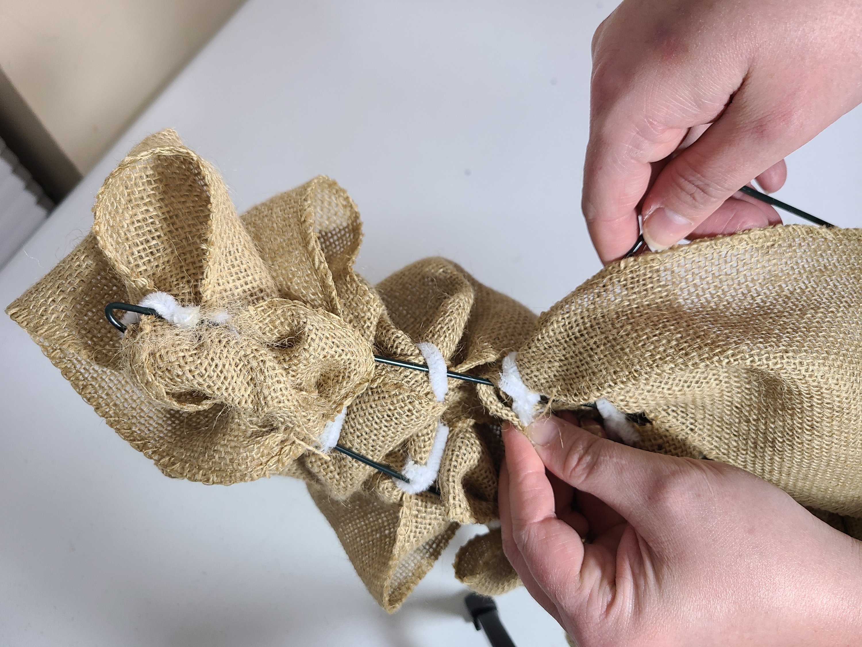 Showing how to attach the burlap to the brim of the burlap witch hat wreath. This is the back view.