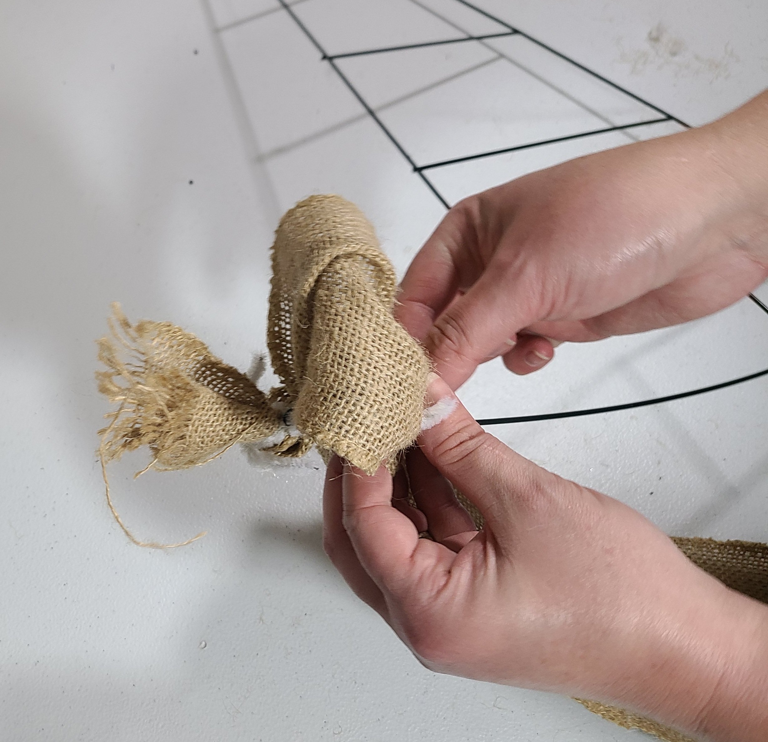 Attaching the burlap 6" from the start to the witch hat wreath to form the first "bubble."
