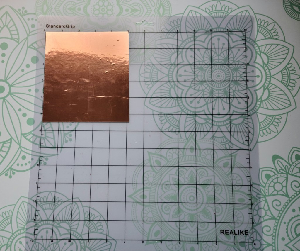 5x5" piece of copper vinyl on a Cricut cutting mat to cut the design on to be placed of the gratitude pumpkin.