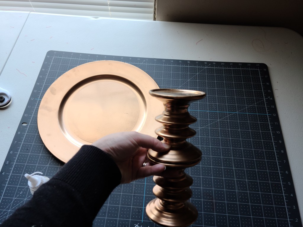 Holding the base of the easy DIY tray (the two candleholders) together while the glue dries.