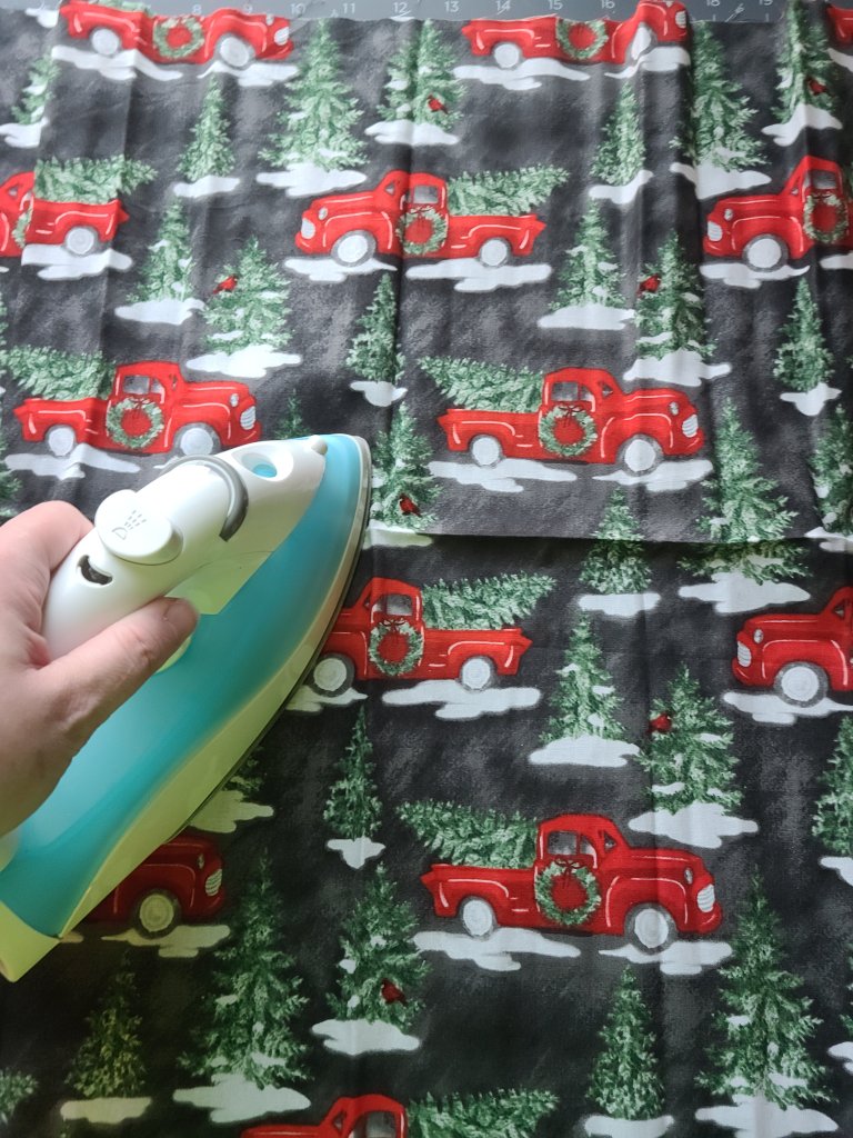 Ironing the wrinkles out of the Christmas fabric.