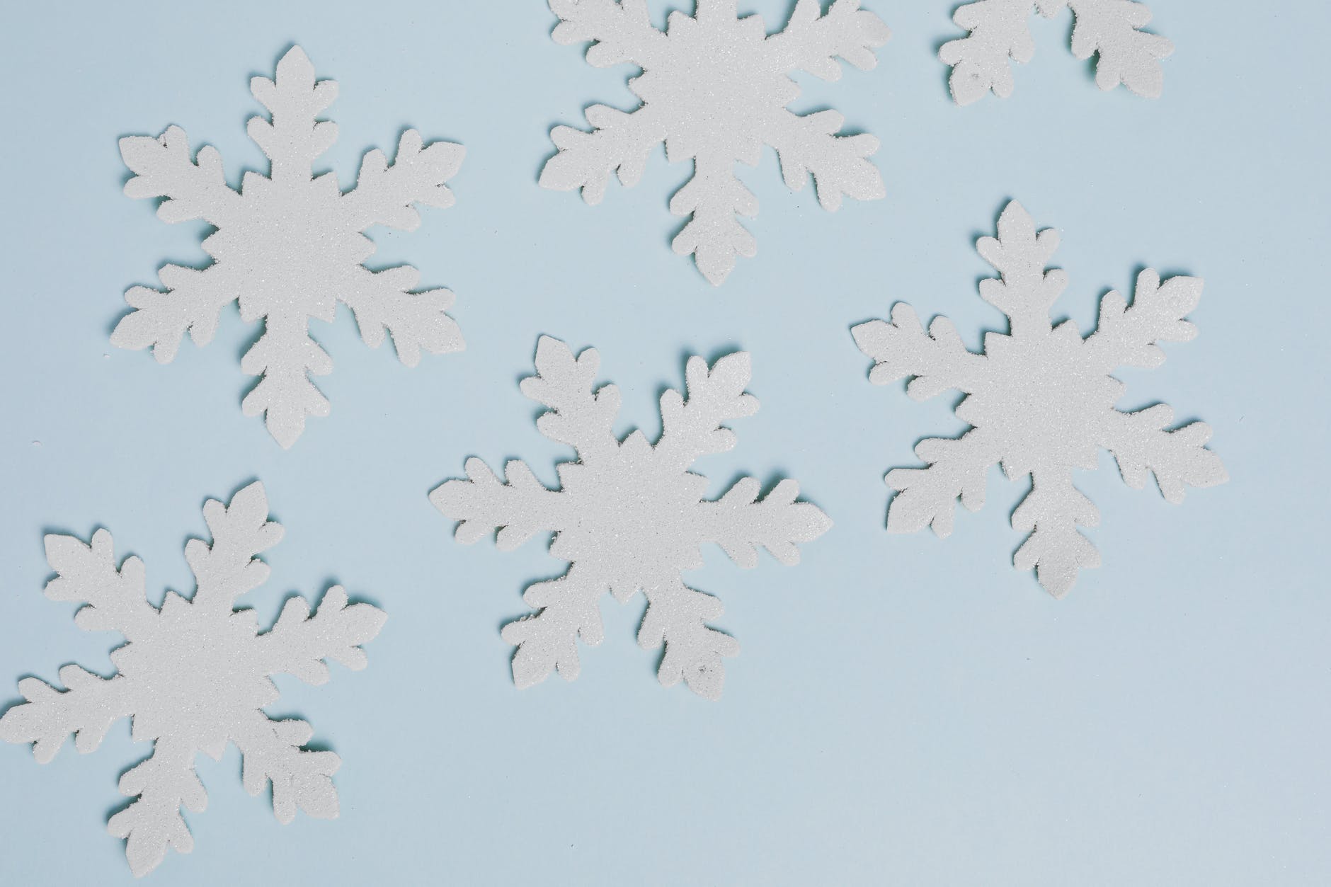 Paper snowflakes on blue background to use an example on Elf family movie night.