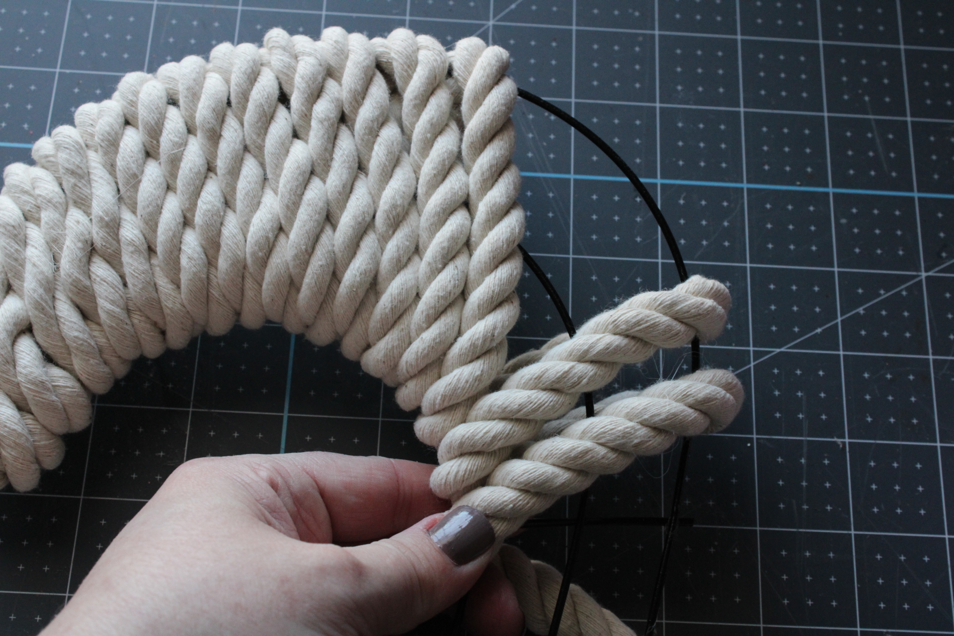 Showing how to skip sections of the heart rope wreath to keep the rope from overlapping in the inner part of one of the arches.