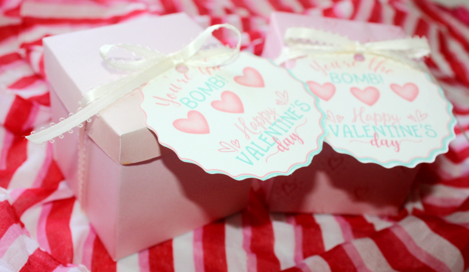 Two Valentine's Day teachers' gifts: bath bombs in a Valentine's Day print gift boxes with tags that say, "You're the BOMB! Happy Valentine's Day!"