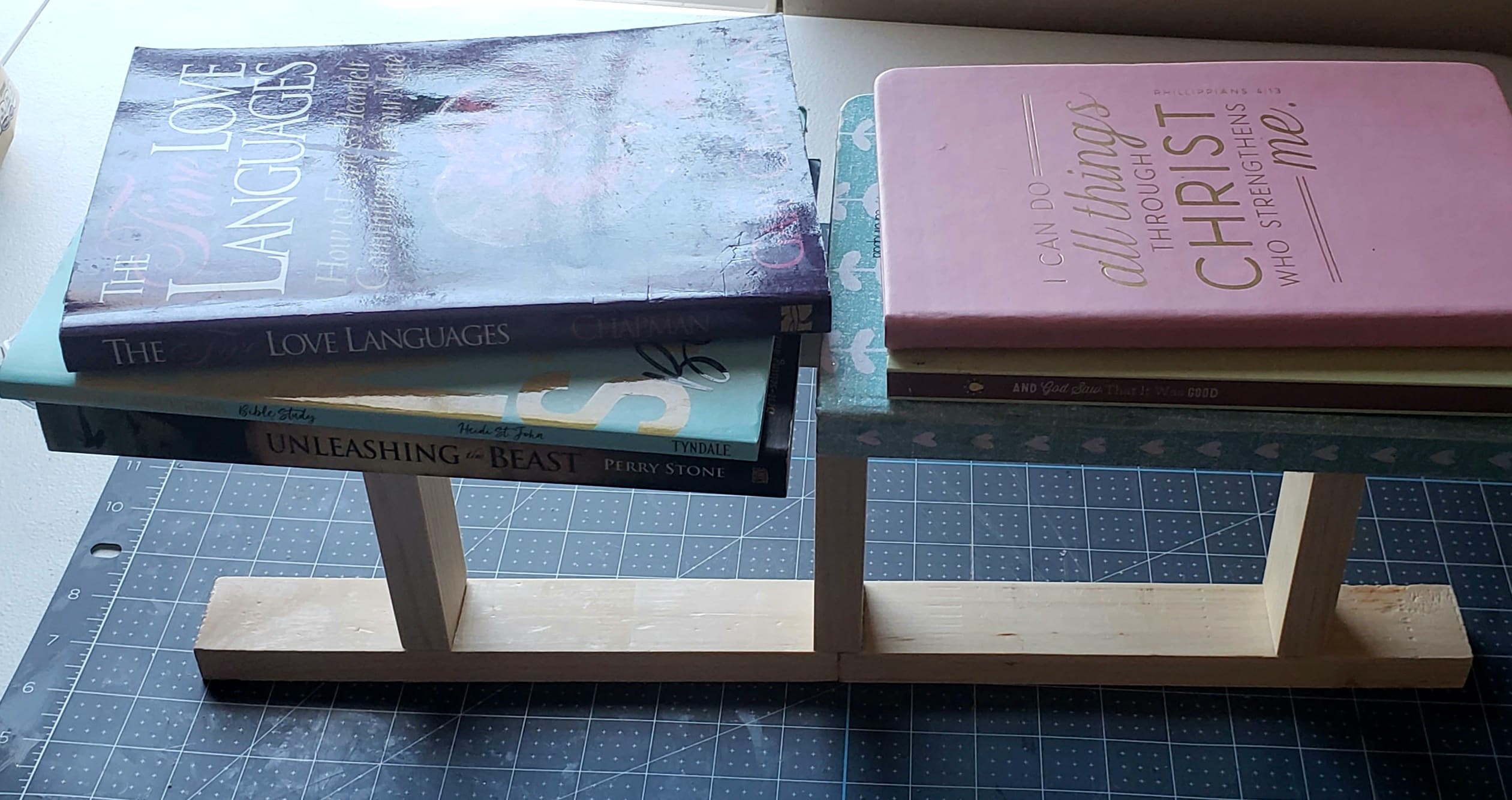 Books laying on top of the tea towel ladder while the glue holding it together dries.