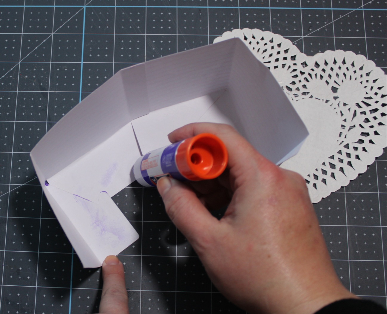 Adding glue to the folded cardstock to glue the box together for the Valentines Day friends gift.