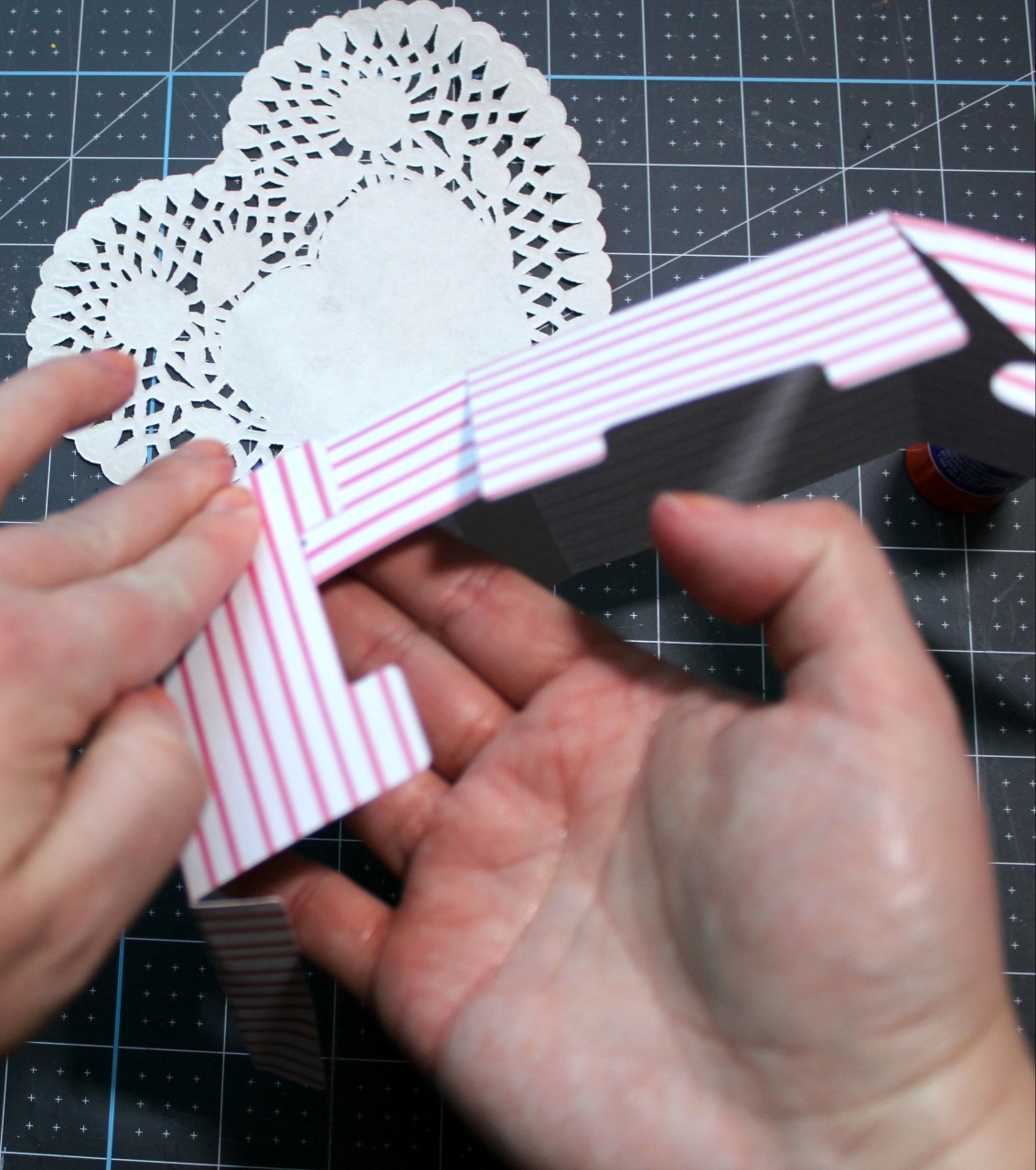Folding the two pieces of cardstock together on the glue to form the box for the Valentines Day friends gift.