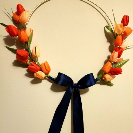 Gold hoop spring wreath form with orange, coral, light salmon wreath with navy silk ribbon.