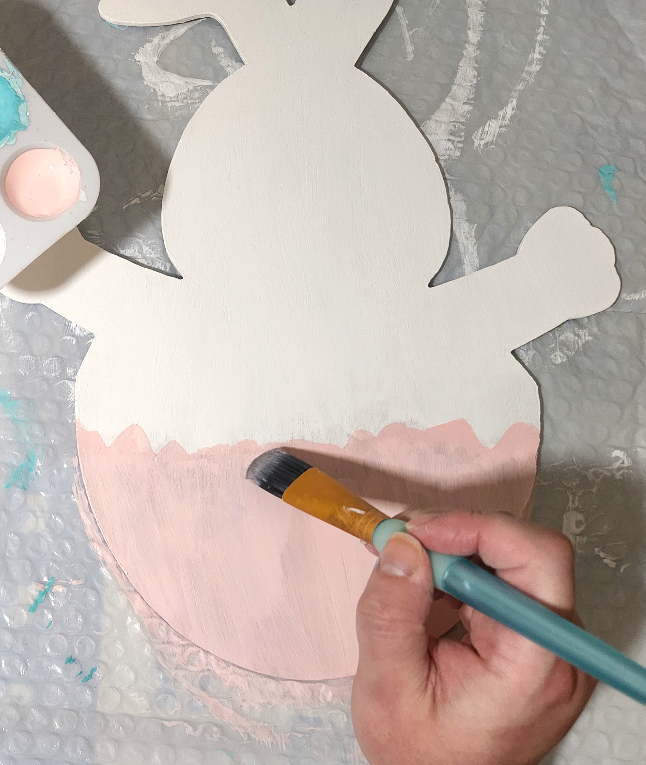 Painting the bottom of the Easter door hanger bunny pink.