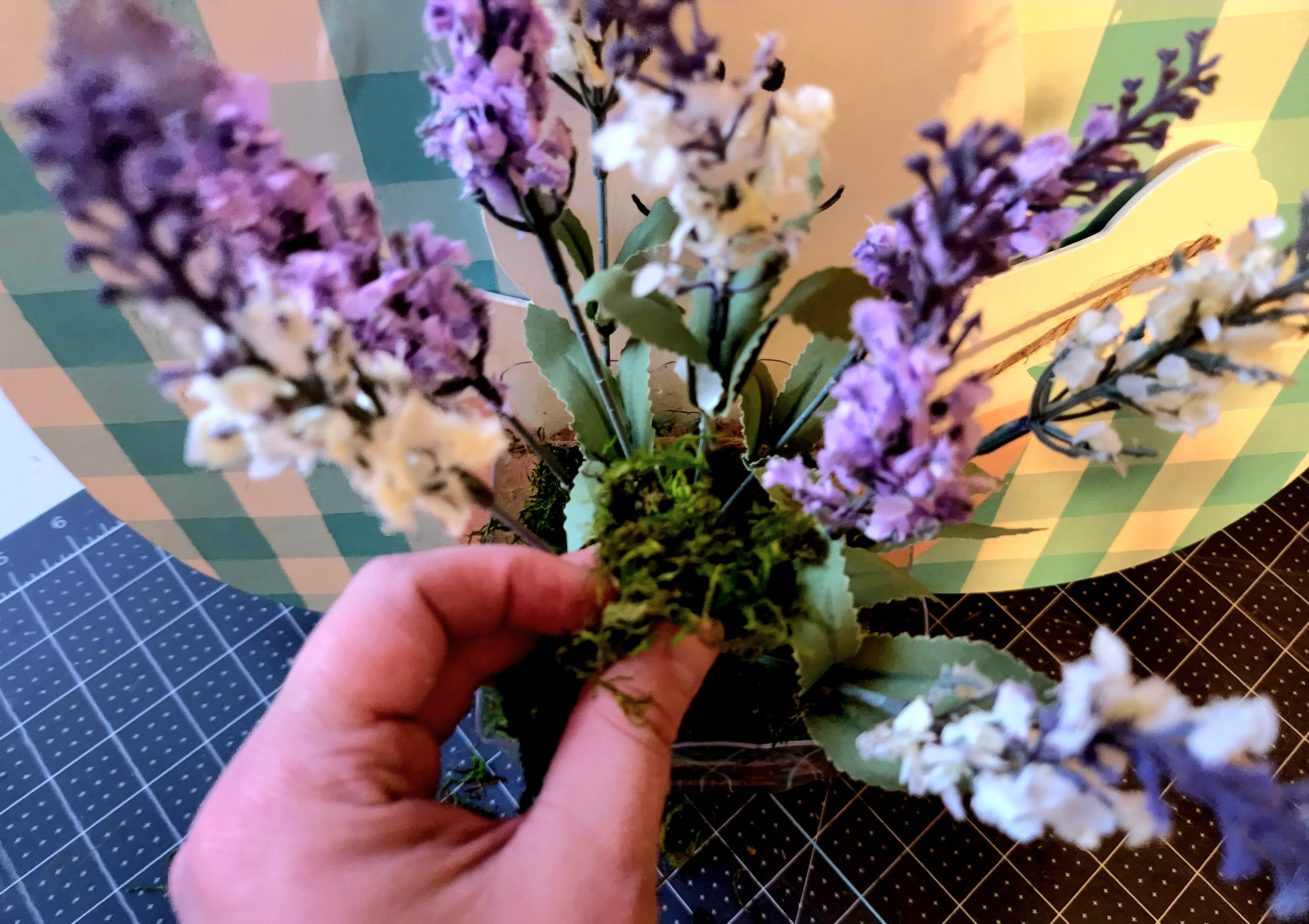 Placing lavender in the vase on the Easter door hanger.