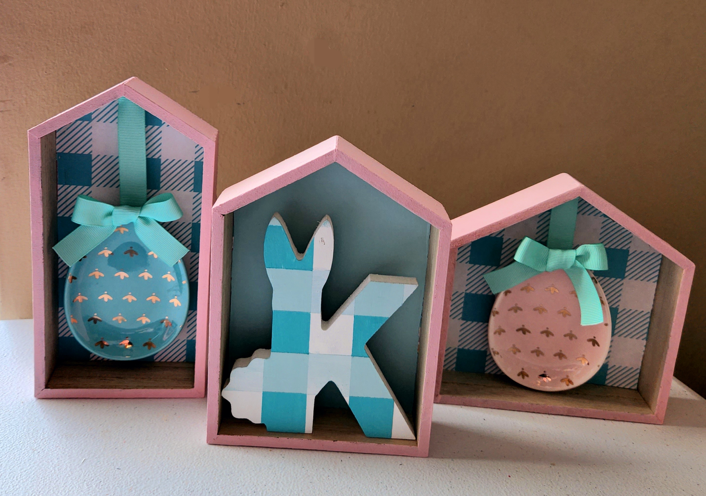 Spring Dollar Tree houses painted pink with spring embellishments inside.