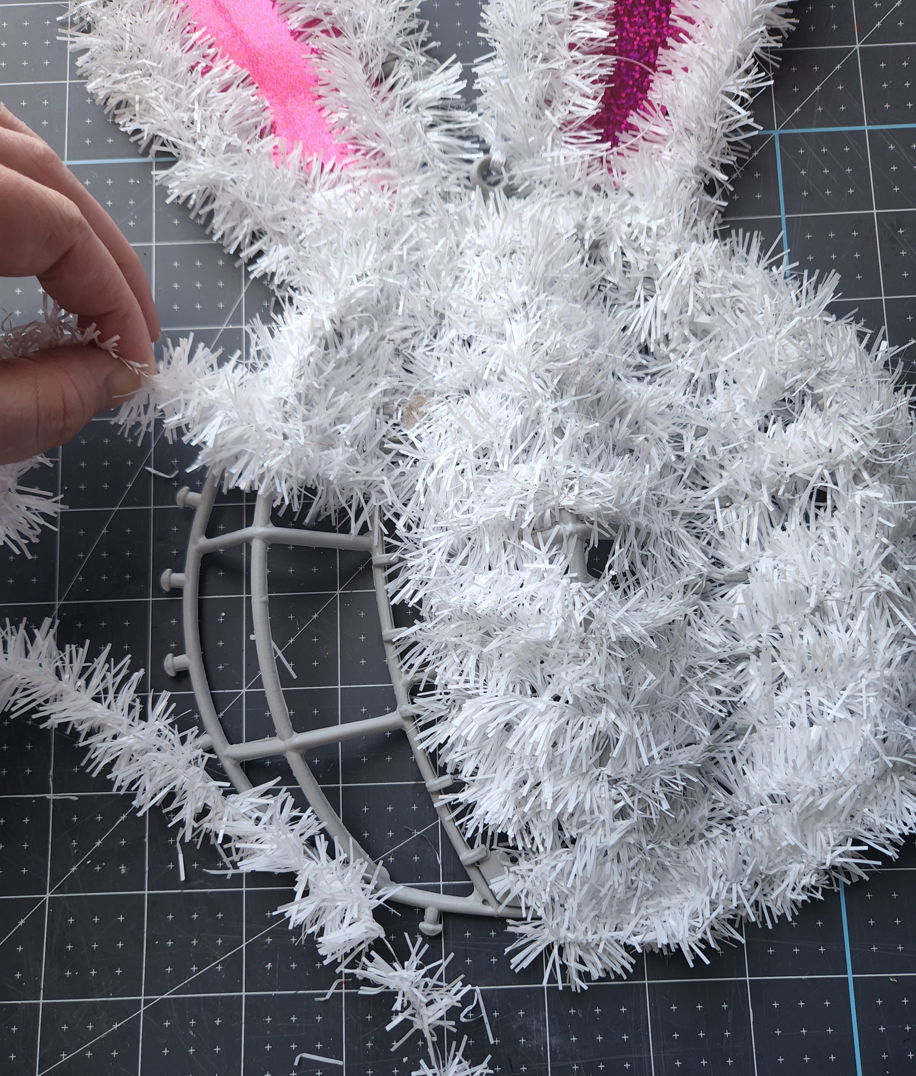 Removing the garland from a Dollar Tree bunny wreath.