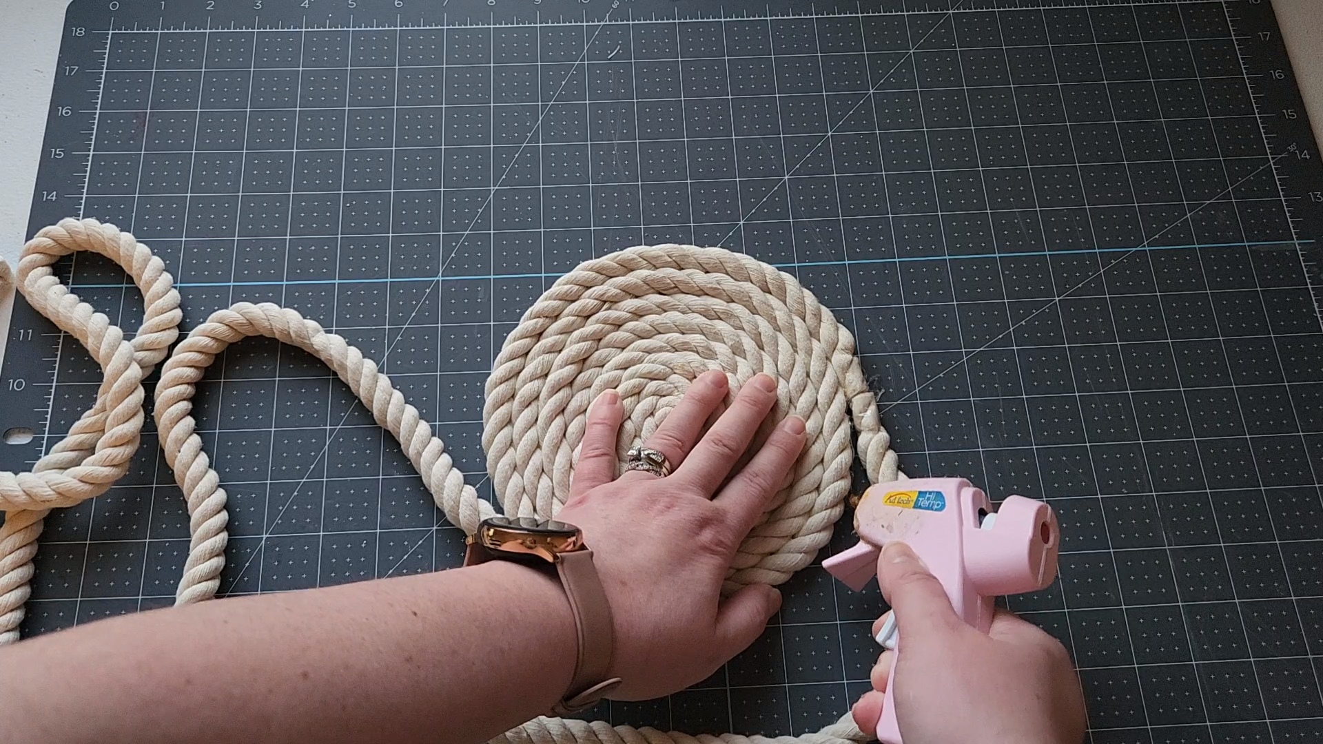 Adding hot glue to the end of the rope to add to the rope tray already forming.