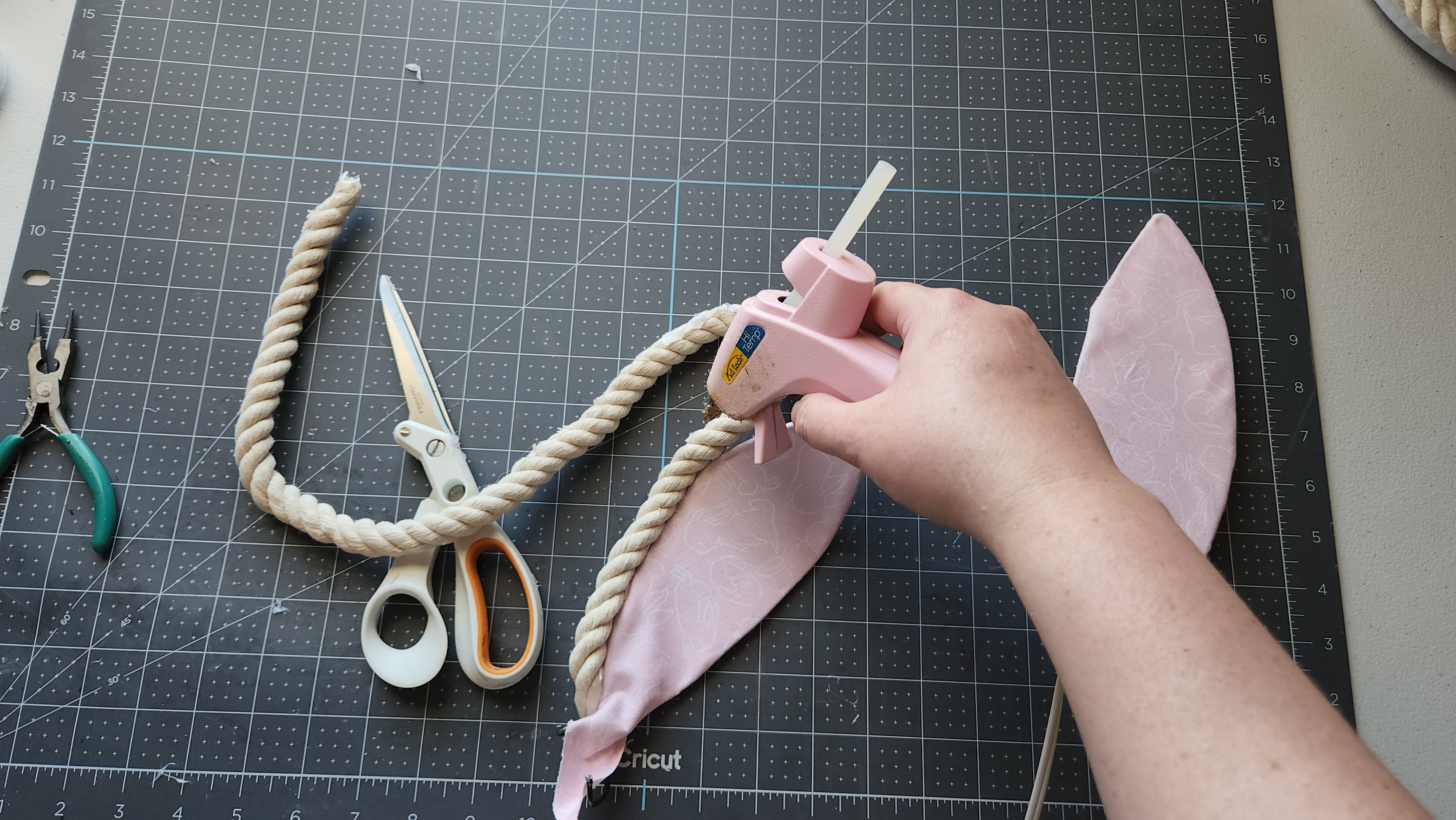 Gluing cotton rope around the edge of the fabric covered bunny ear.