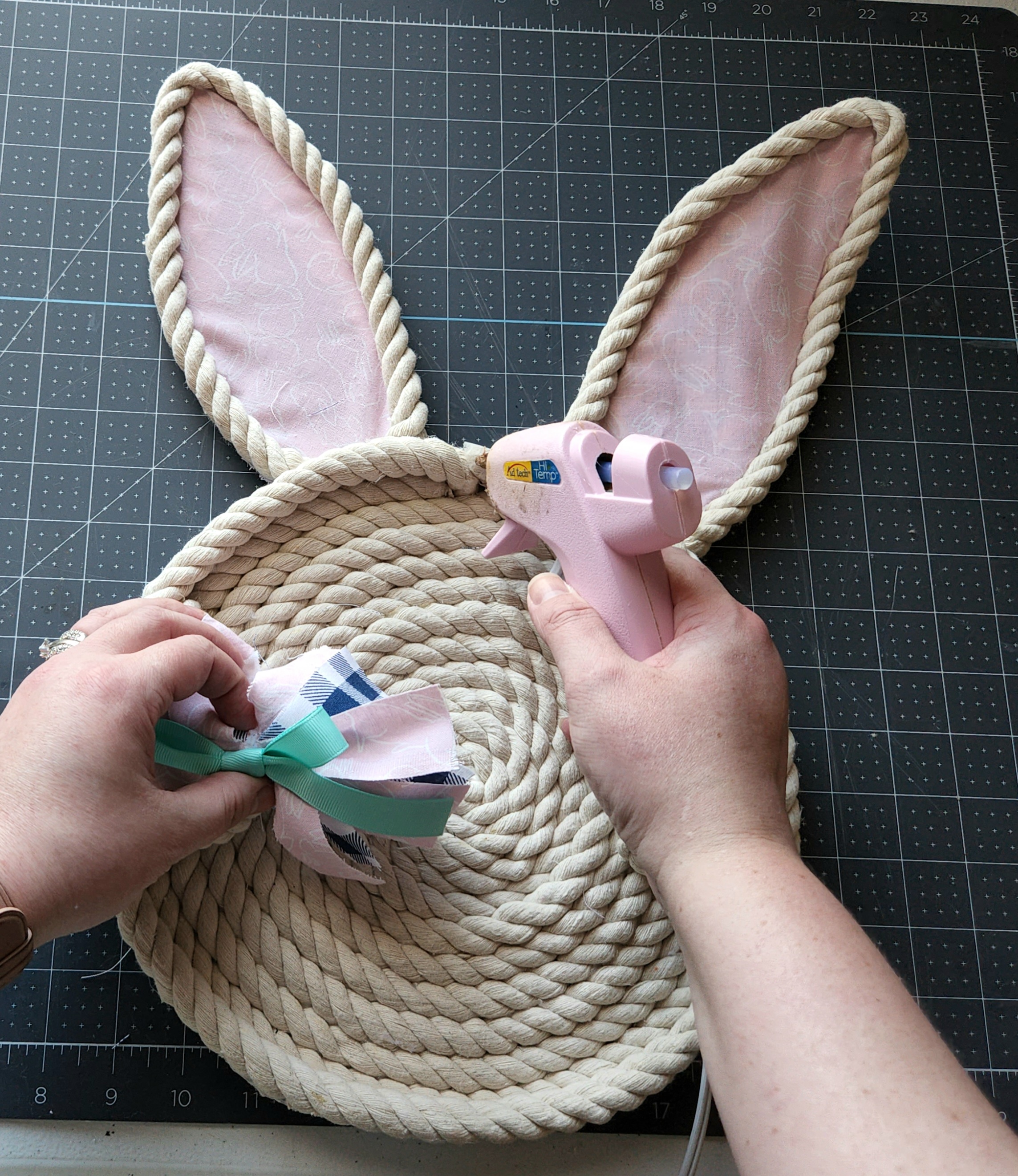 Gluing a bow onto the rope bunny tray.