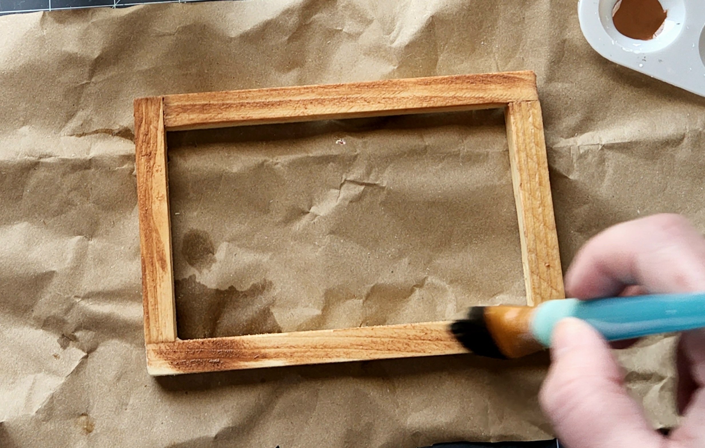 Brushing watered down paint on the Dollar Tree canvas wood frame.