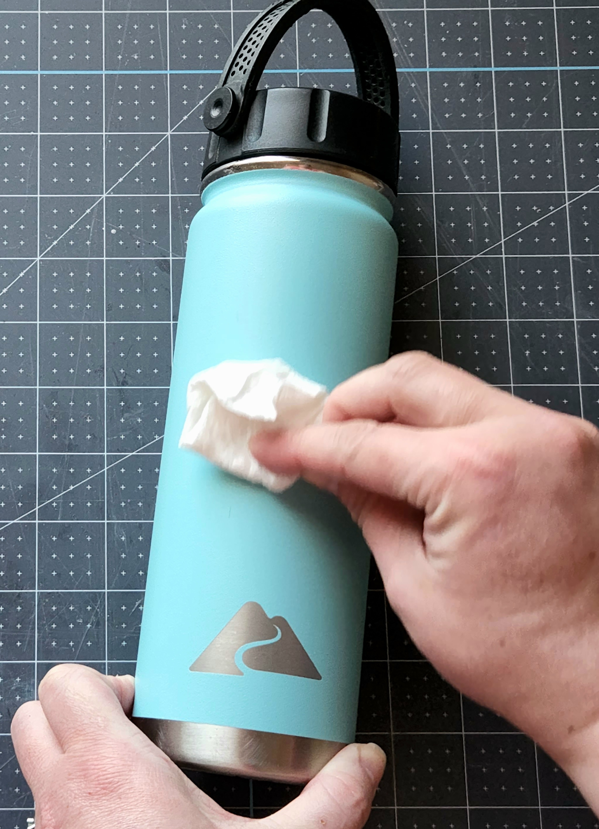 Cleaning the tumbler with alcohol before applying a childs handwriting I cut with a Cricut.