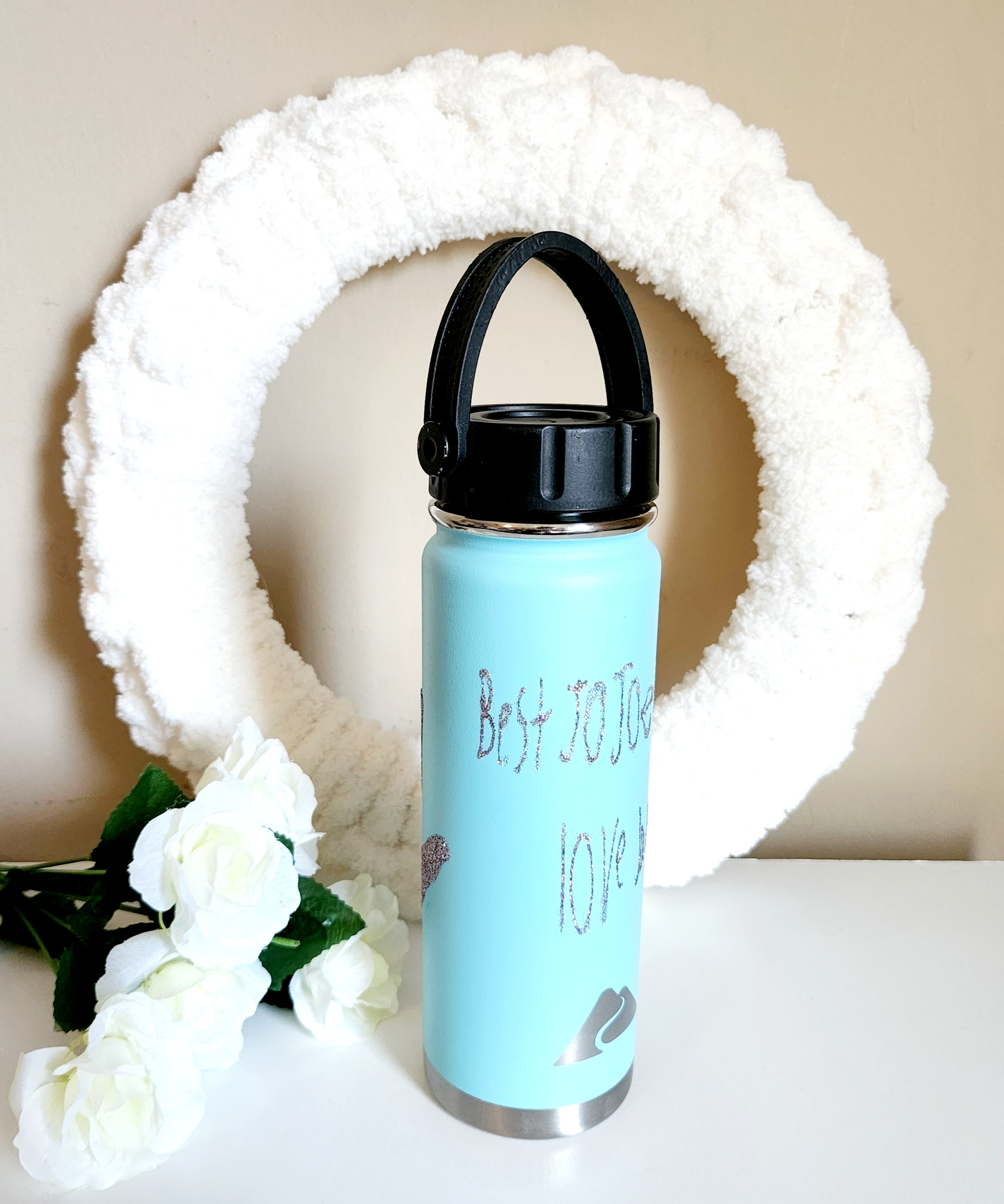 Childs handwriting cut with a Cricut in unicorn glitter HTV and applied to an aqua tumbler.
