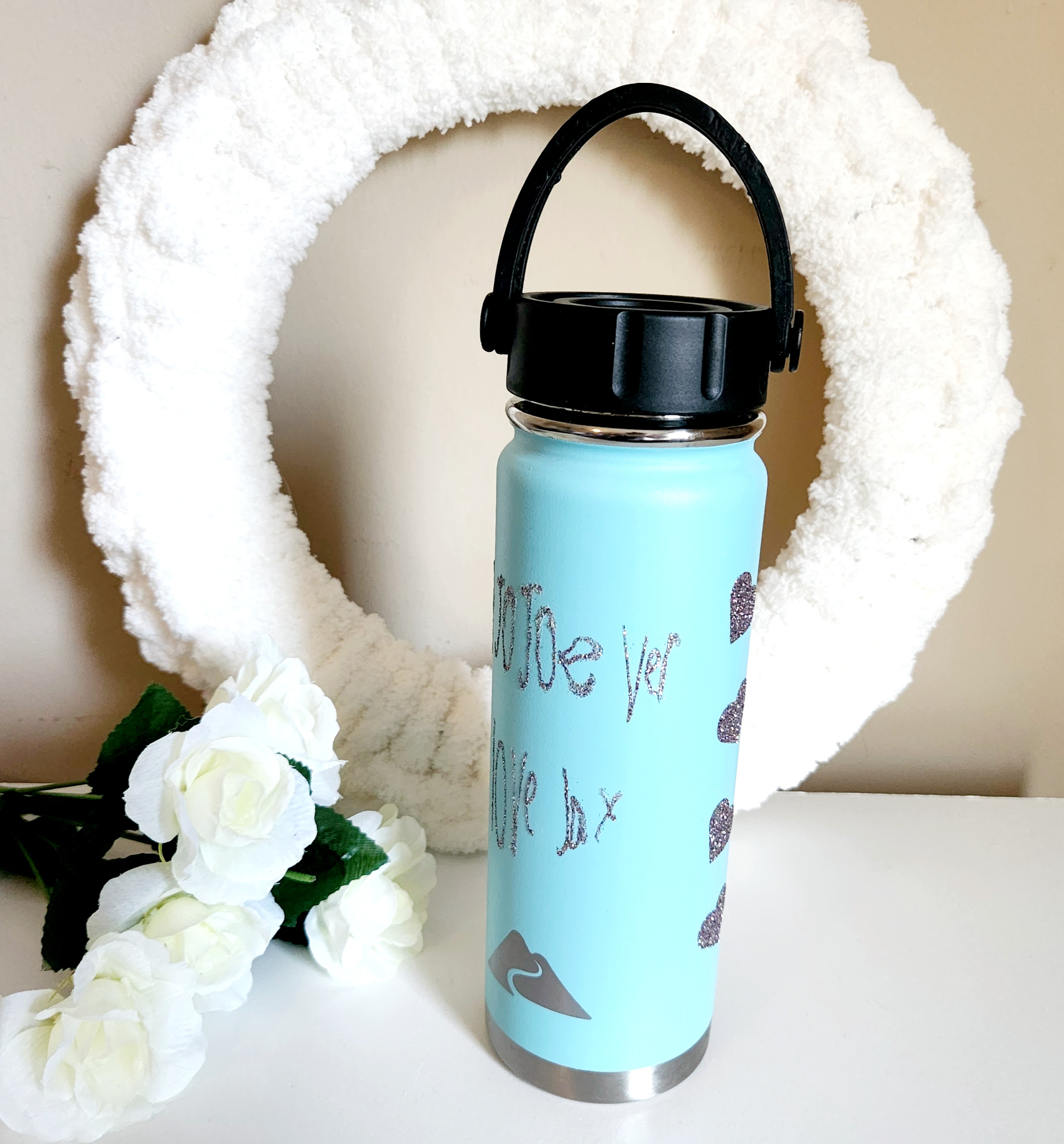 Childs handwriting cut with a Cricut in unicorn glitter HTV and applied to an aqua tumbler.