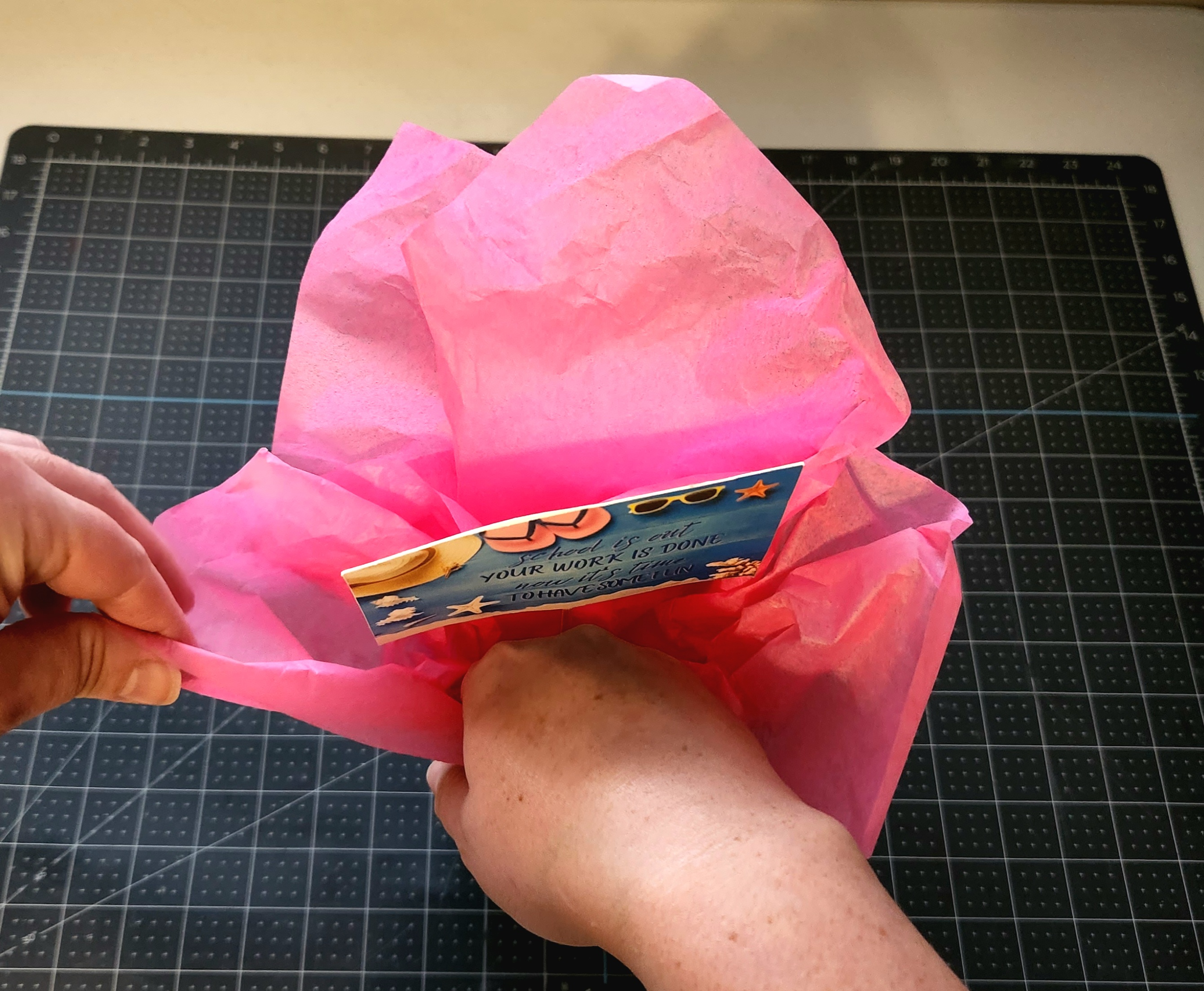Placing the gift tag and tissue paper into the tumbler.