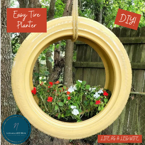 DIY tire planter: yellow tire with red and white impatients planted inside.