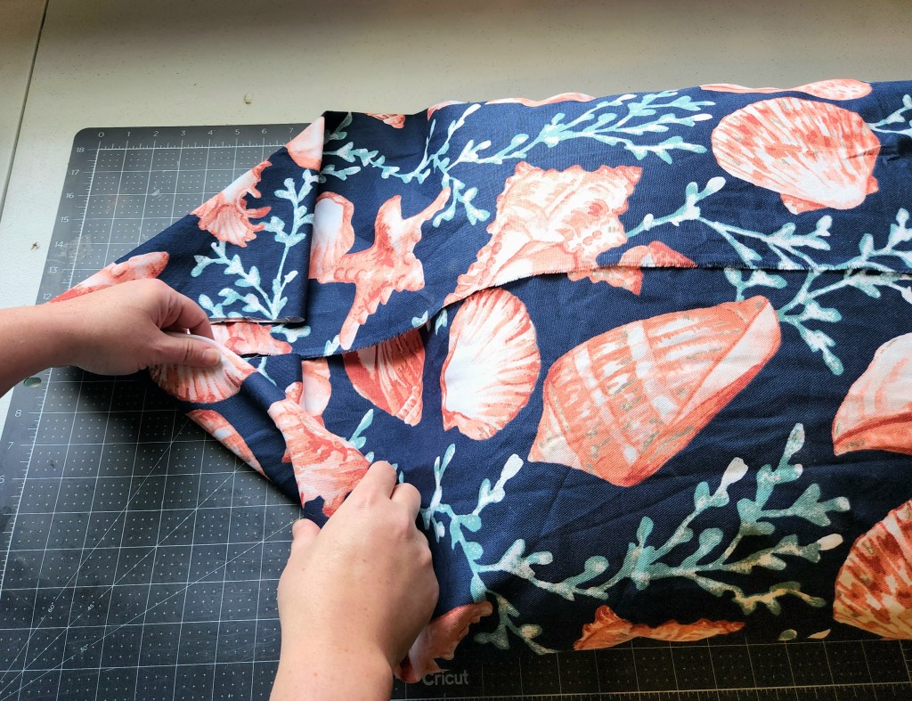 Folding the ends of the fabric in to make a no sew pillowcase.