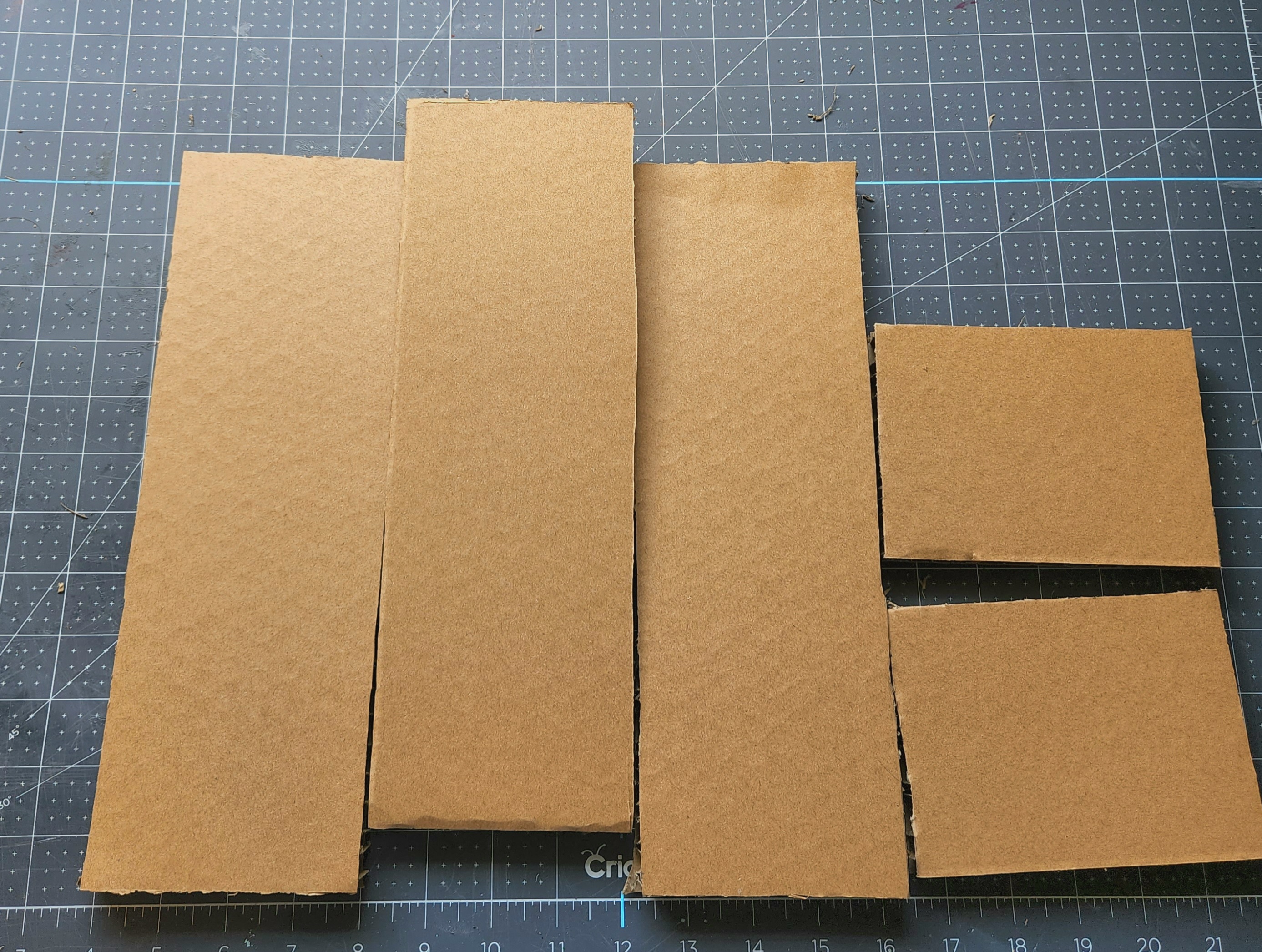 Five pieces of cardboard cut out that will form the DIY wood planter box/coastal centerpiece.