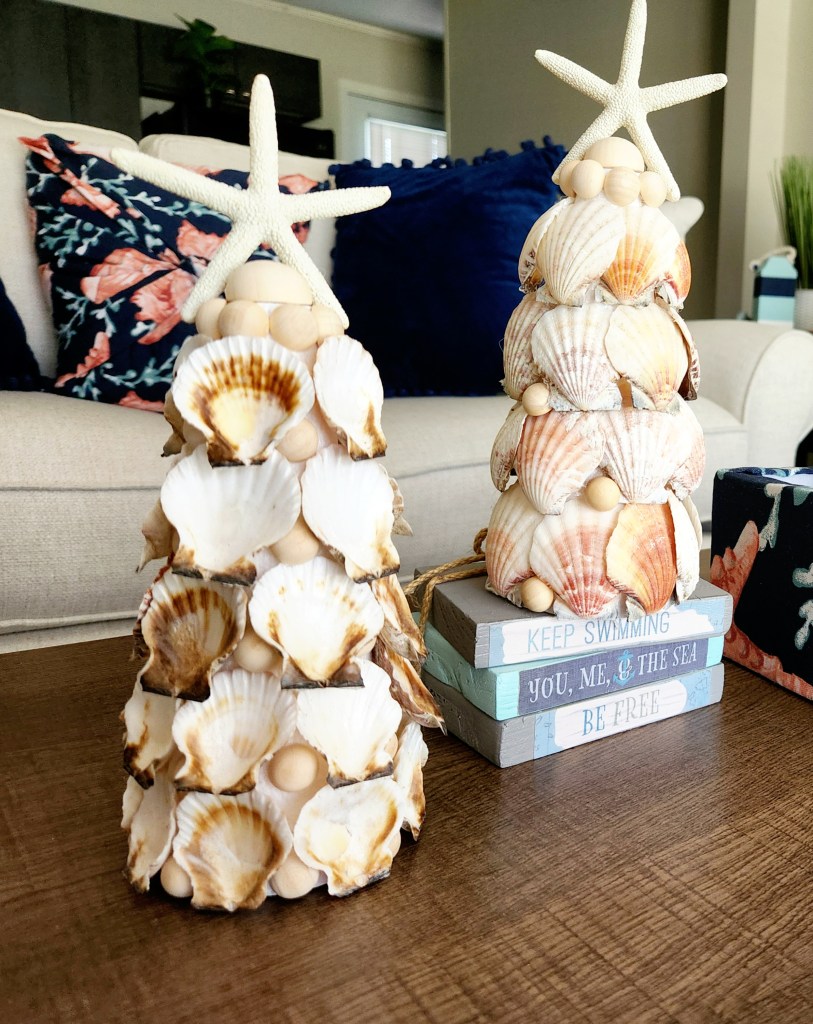 Two seashell Christmas trees, one with the shells glued on face forward and on with the shells on backward, both with starfish toppers.