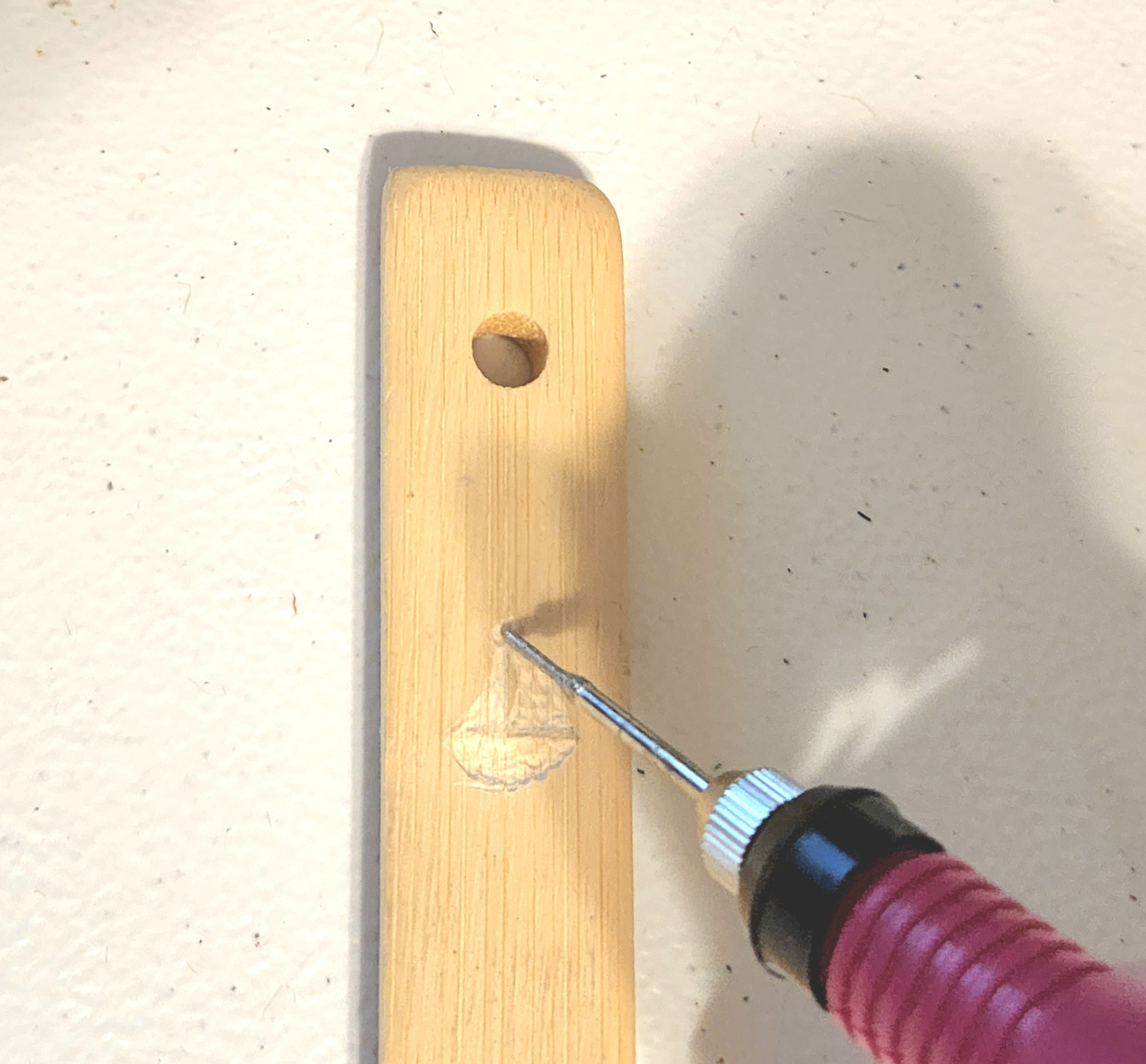 Going over a sailboat design with an etcher on a wood spoon.