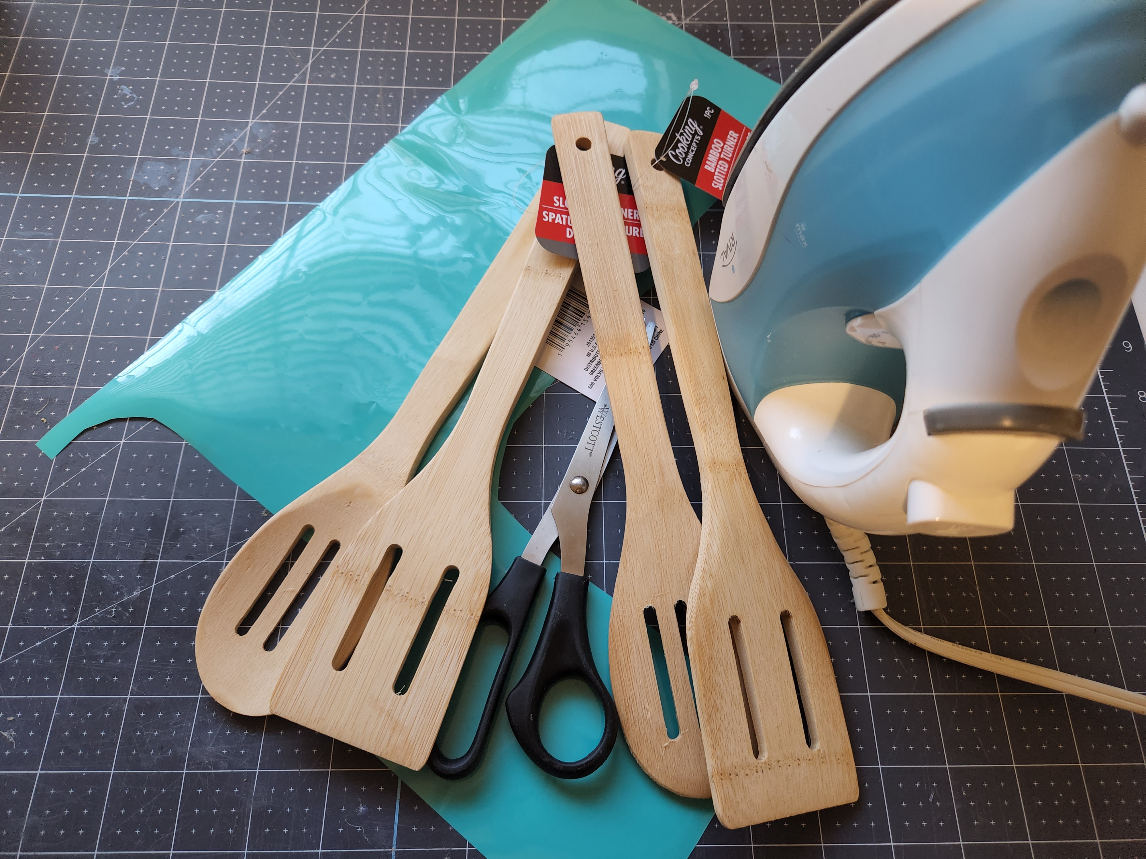 Supplies for an etched wood spoon: wood spoons or spatulas, scissors, a dremel, or an iron and heat transfer vinyl.
