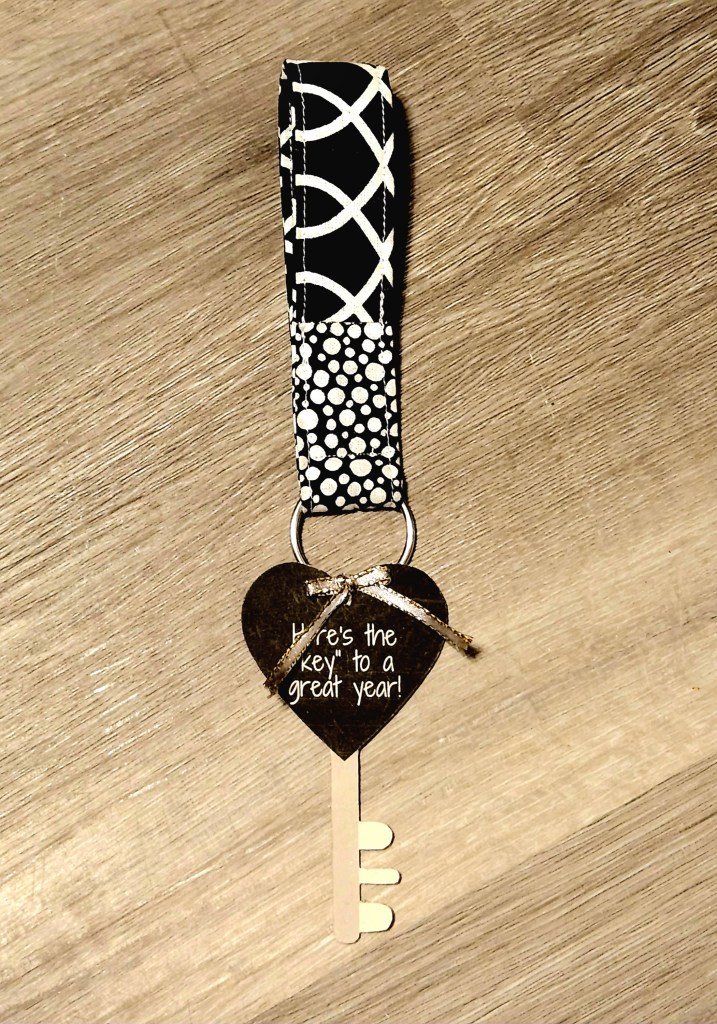 Key fob keychain made with two coordinating black and white fabrics with a key shaped teacher gift tag reading, "Here's the 'key' to a great year!", tied onto the keyring.
