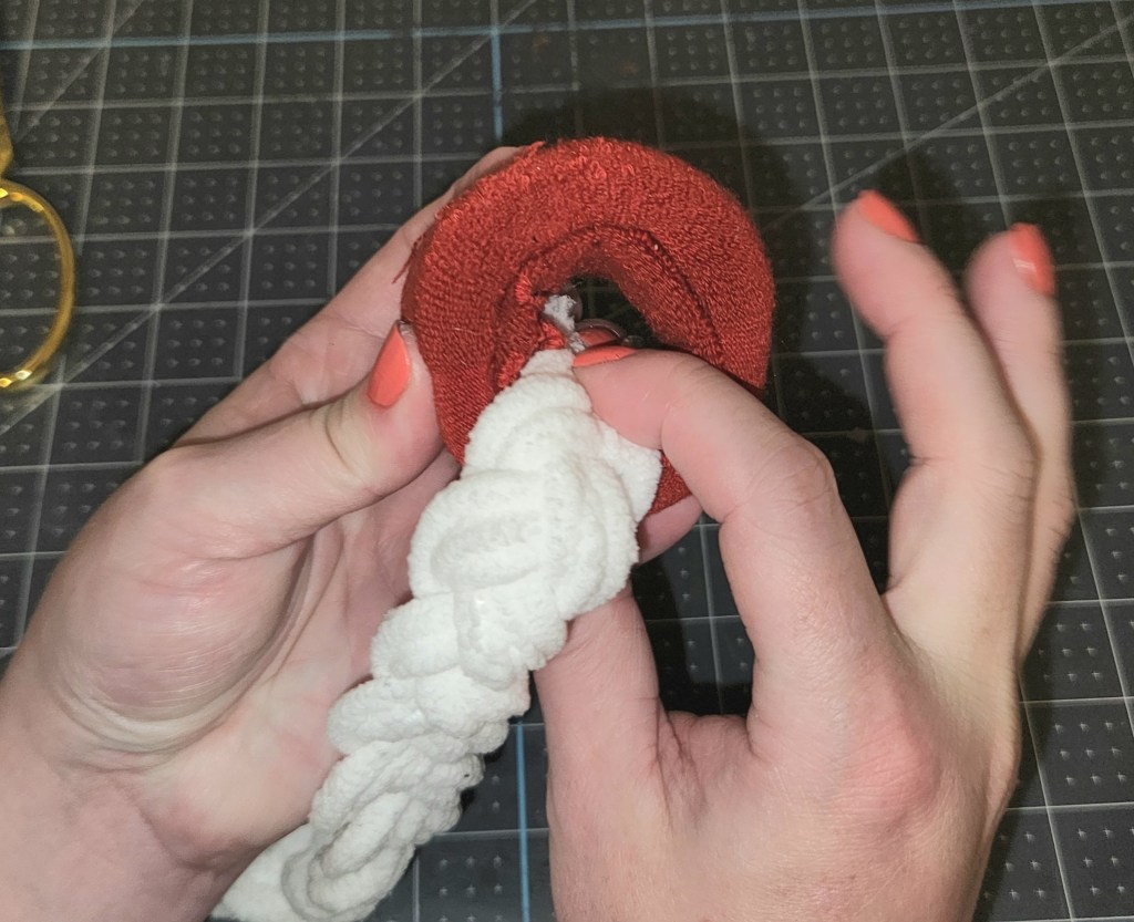 Gluing the end of the yarn braid inside the sock bun donut.