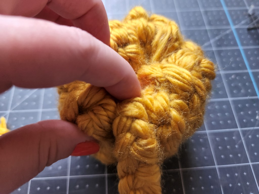 Pressing the last crocheted section of yarn into the middle of the donut.