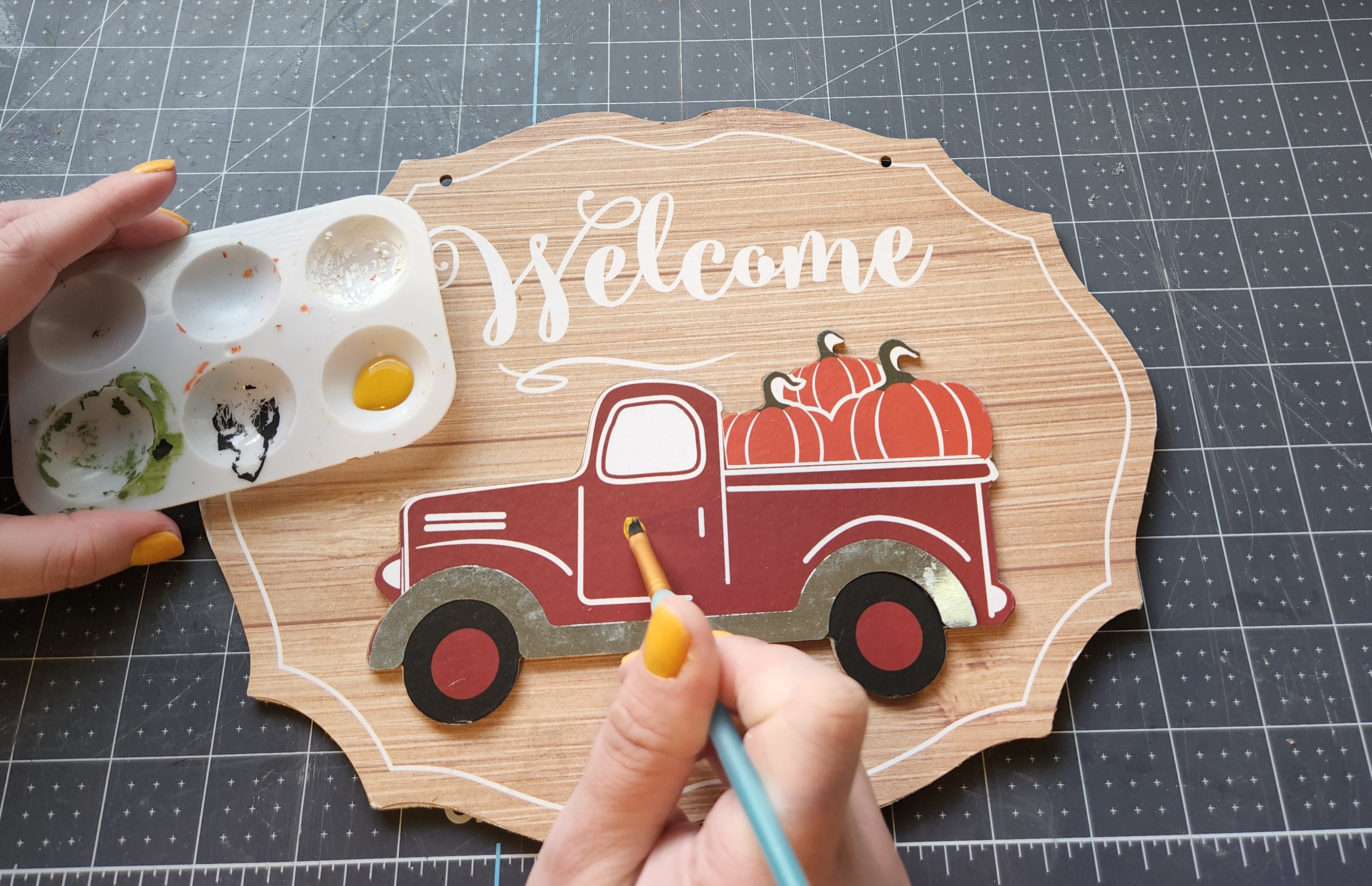 Painting over the farmhouse truck on the welcome sign.