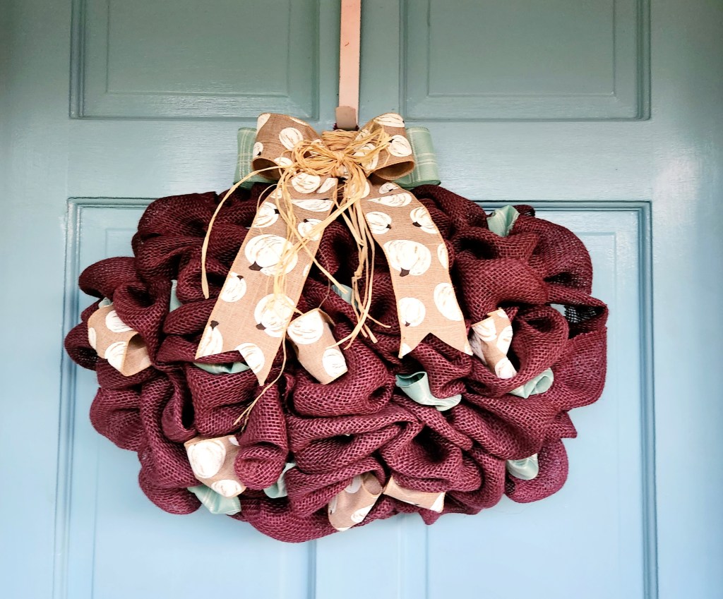 Purple burlap pumpkin wreath with mint bow & tan with white pumpkins ribbon accents.