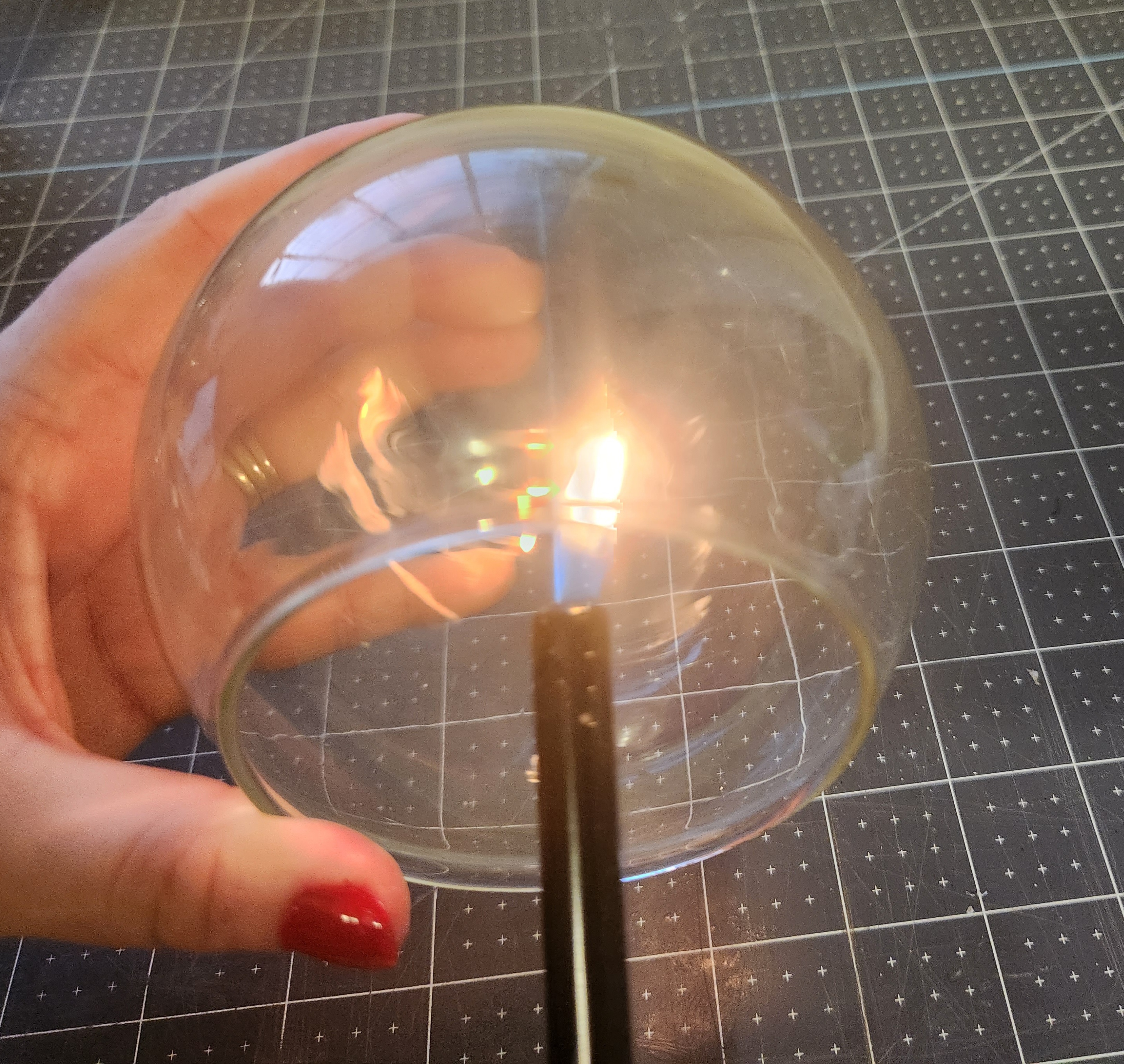 Using a lighter to create soot inside a round glass vase.