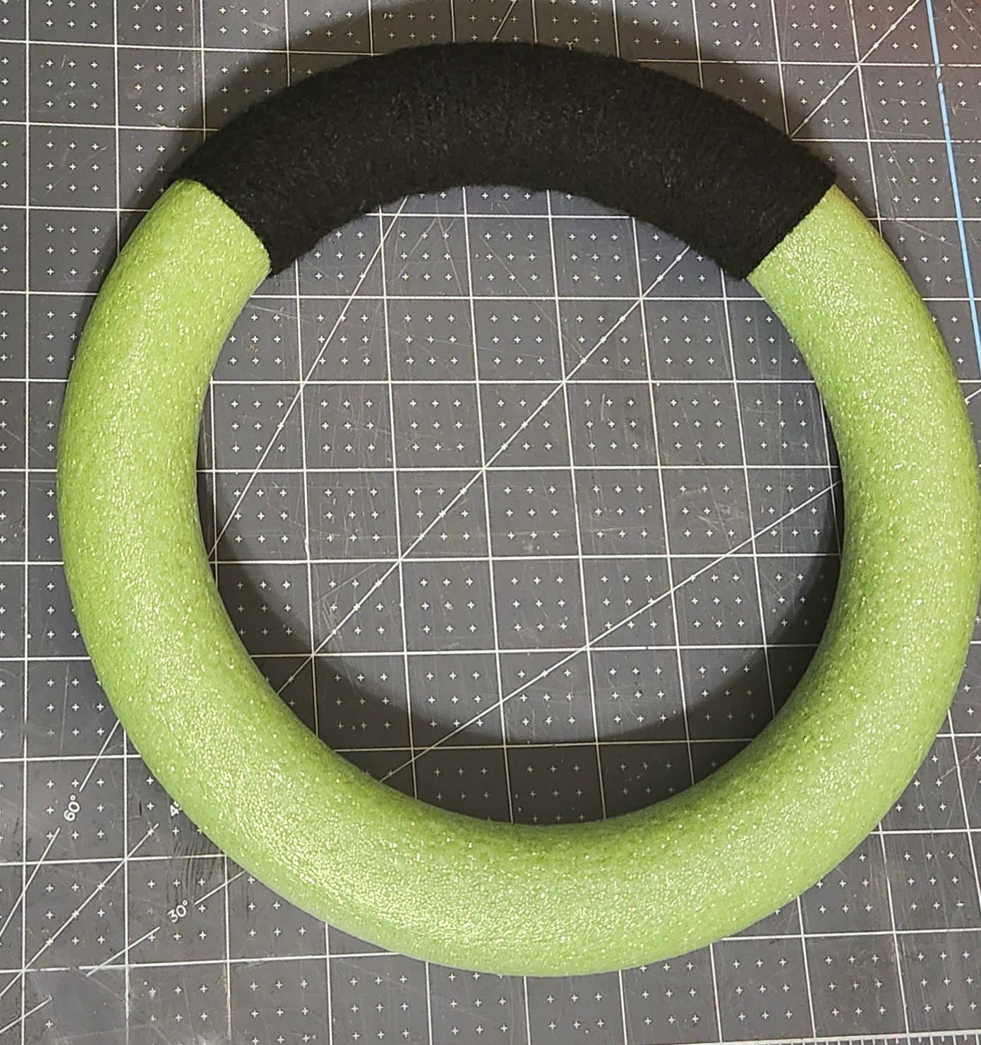 A quarter of a styrofoam wreath form covered with black yarn.